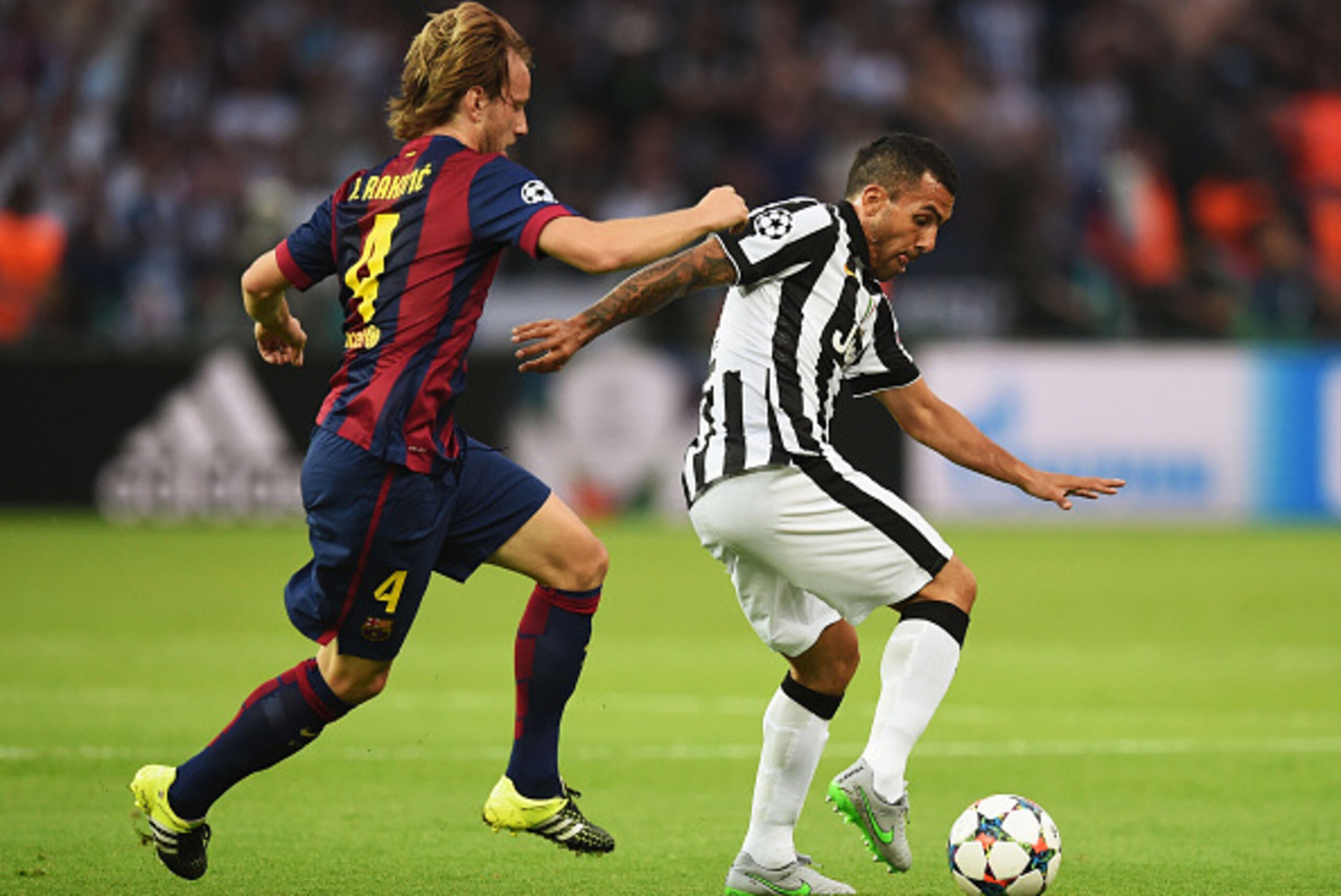 BERLIN, GERMANY - JUNE 06: Carlos Tevez of Juventus is tackled by Ivan Rakitic of Barcelona during the UEFA Champions League Final between Juventus and FC Barcelona at Olympiastadion on June 6, 2015 in Berlin, Germany.  (Photo by Matthias Hangst/Getty Ima