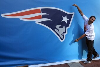 INDIANAPOLIS, IN - FEBRUARY 01:  A fan poses for a photo next to a giant New England Patriots logo prior to Super Bowl XLVI between the New York Giants and the New England Patriots on February 1, 2012 in Indianapolis, Indiana.  (Photo by Scott Halleran/Ge