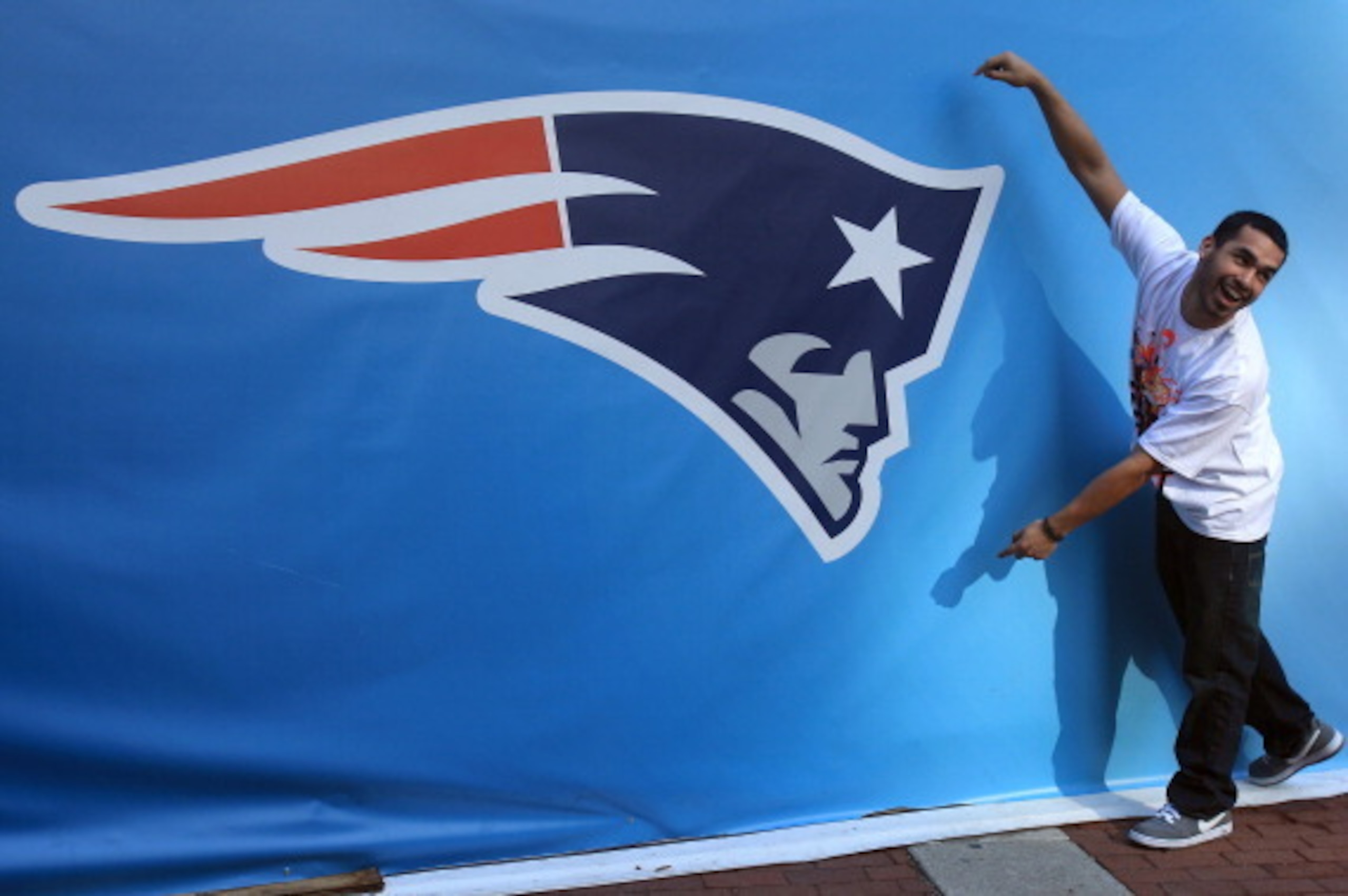INDIANAPOLIS, IN - FEBRUARY 01:  A fan poses for a photo next to a giant New England Patriots logo prior to Super Bowl XLVI between the New York Giants and the New England Patriots on February 1, 2012 in Indianapolis, Indiana.  (Photo by Scott Halleran/Ge