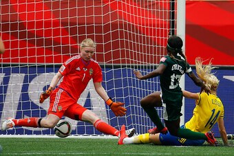 WINNIPEG, MB - JUNE 08:  Francisca Ordega #17 of Nigeria scores the game-tying goal past Amanda Ilestedt #14 and goalkeeper Hedvig Lindahl #1 of Sweden during the FIFA Women's World Cup Canada 2015 Group D match between Sweden and Nigeria at Winnipeg Stad