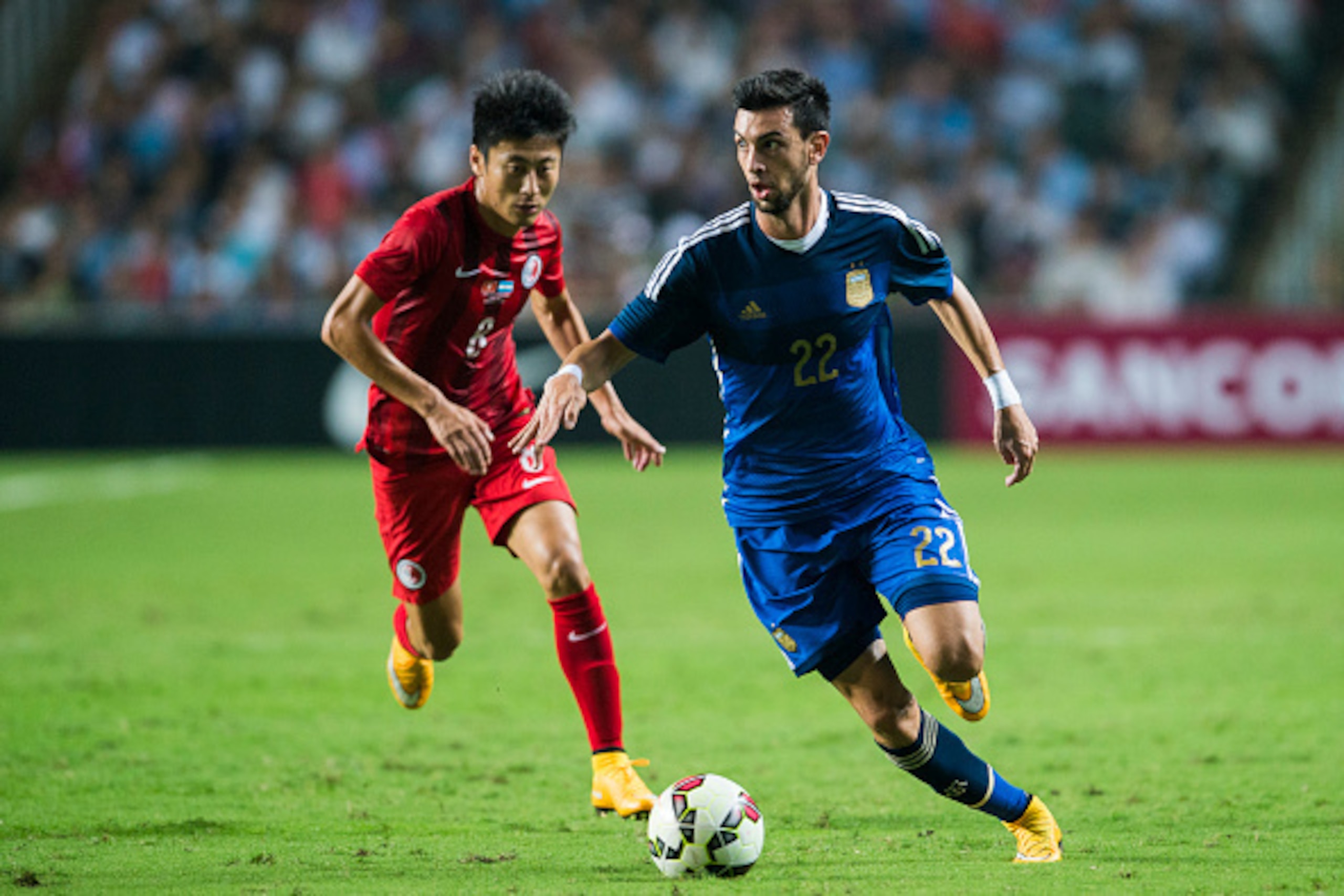 HONG KONG - OCTOBER 14: Javier Pastore (R) of Argentina and Yang Huang of Hong Kong in action during the International Friendly Match between Hong Kong and Argentina at the Hong Kong Stadium on October 14, 2014 in Hong Kong, Hong Kong.  (Photo by Victor F