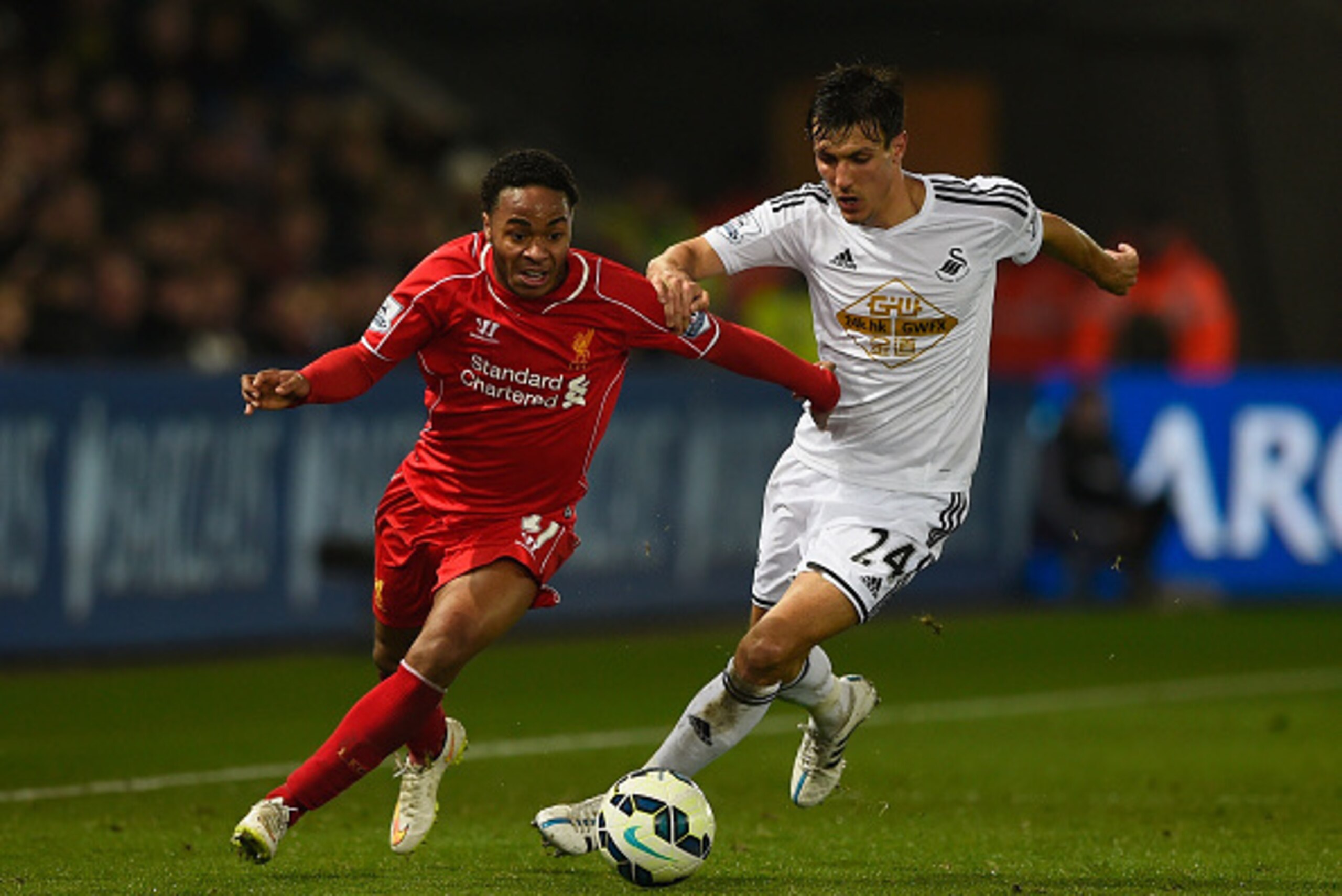 SWANSEA, WALES - MARCH 16:  Raheem Sterling of Liverpool is challenged by Jack Cork of Swansea during the Barclays Premier League match between Swansea City and Liverpool at Liberty Stadium on March 16, 2015 in Swansea, Wales.  (Photo by Mike Hewitt/Getty