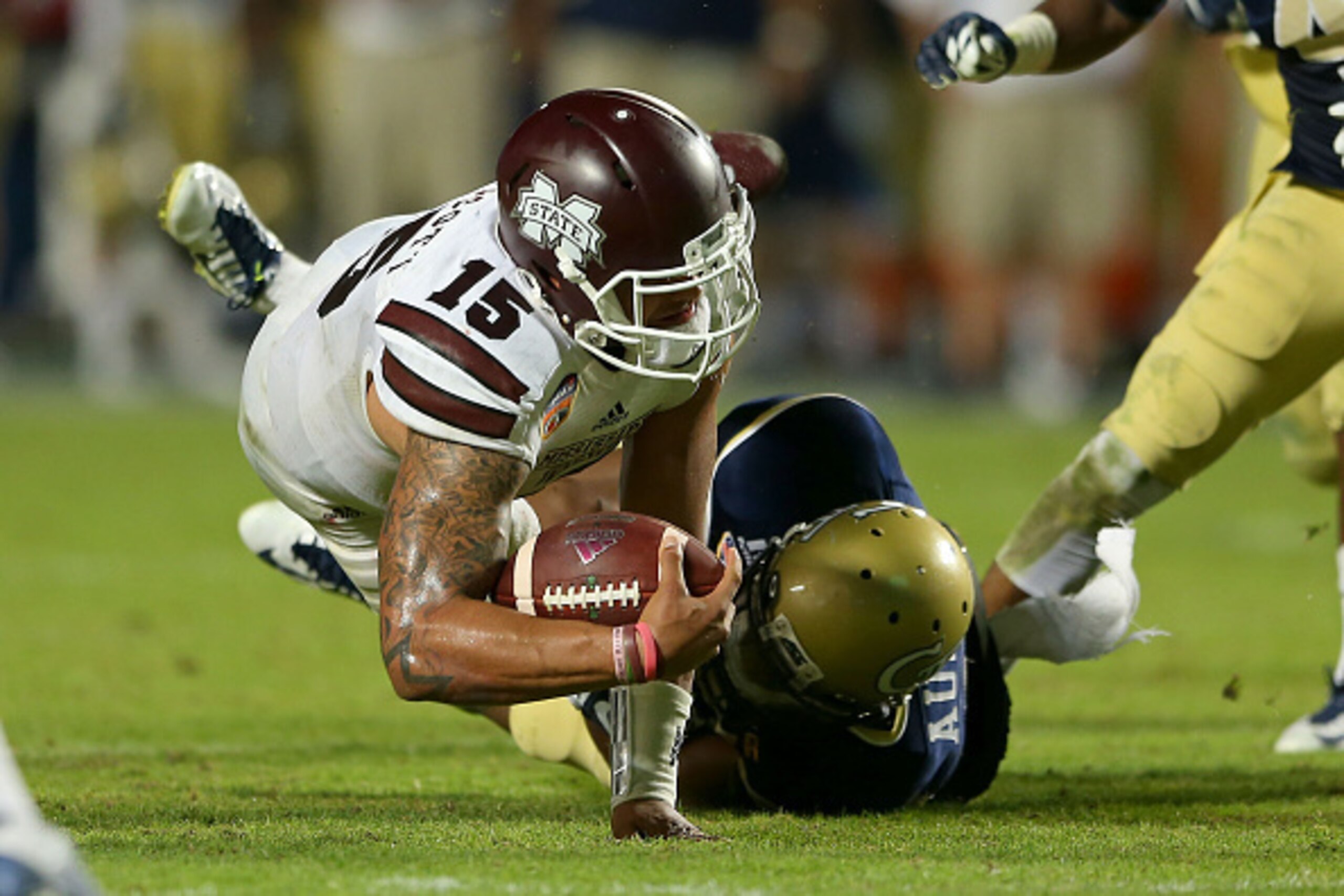 MIAMI GARDENS, FL - DECEMBER 31: Dak Prescott #15 of the Mississippi State Bulldogs reaches for extra yards during the Capital One Orange Bowl game against the Mississippi State Bulldogs at Sun Life Stadium on December 31, 2014 in Miami Gardens, Florida. 