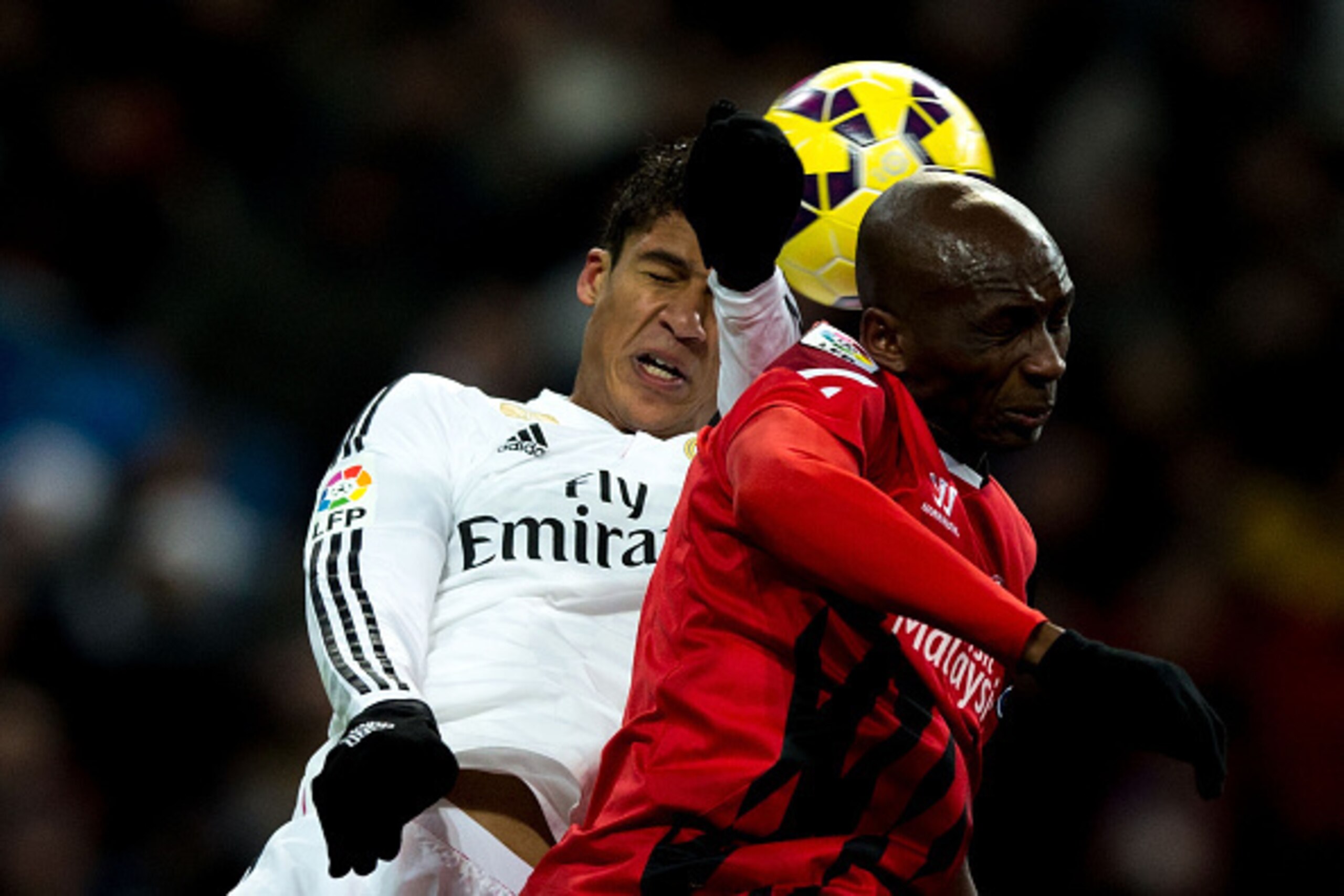 MADRID, SPAIN - FEBRUARY 04: Raphael Varane of Real Madrid CF wins the header before Stephane Mbia Etoundi of Sevilla FC during the La Liga match between Real Madrid CF and Sevilla FC at Estadio Santiago Bernabeu on February 4, 2015 in Madrid, Spain.  (Ph
