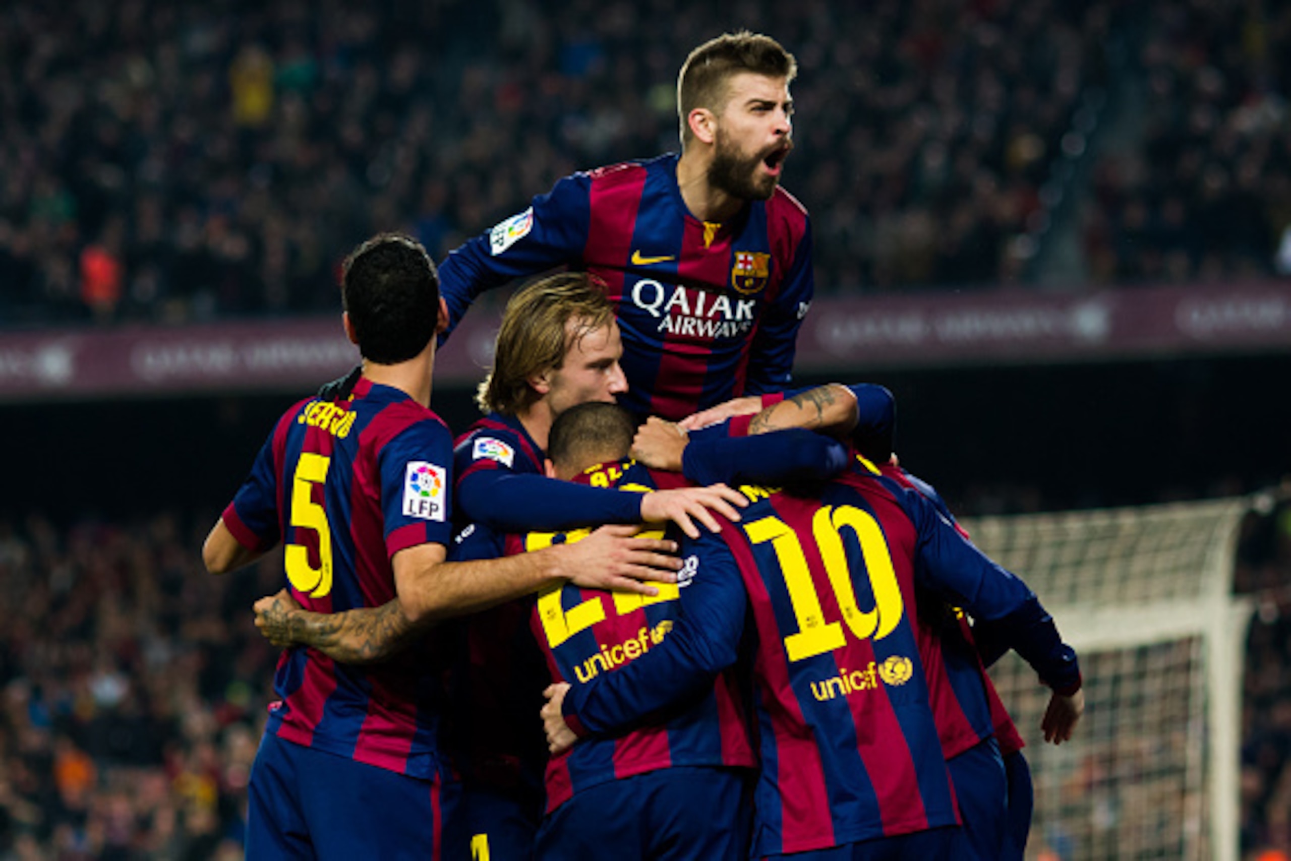 BARCELONA, SPAIN - JANUARY 11: Players of FC Barcelona as Gerard Pique (top) celebrate with their team-mate Neymar Santos Jr after he scored the opening goal during the La Liga match between FC Barcelona and Club Atletico de Madrid at Camp Nou on January 