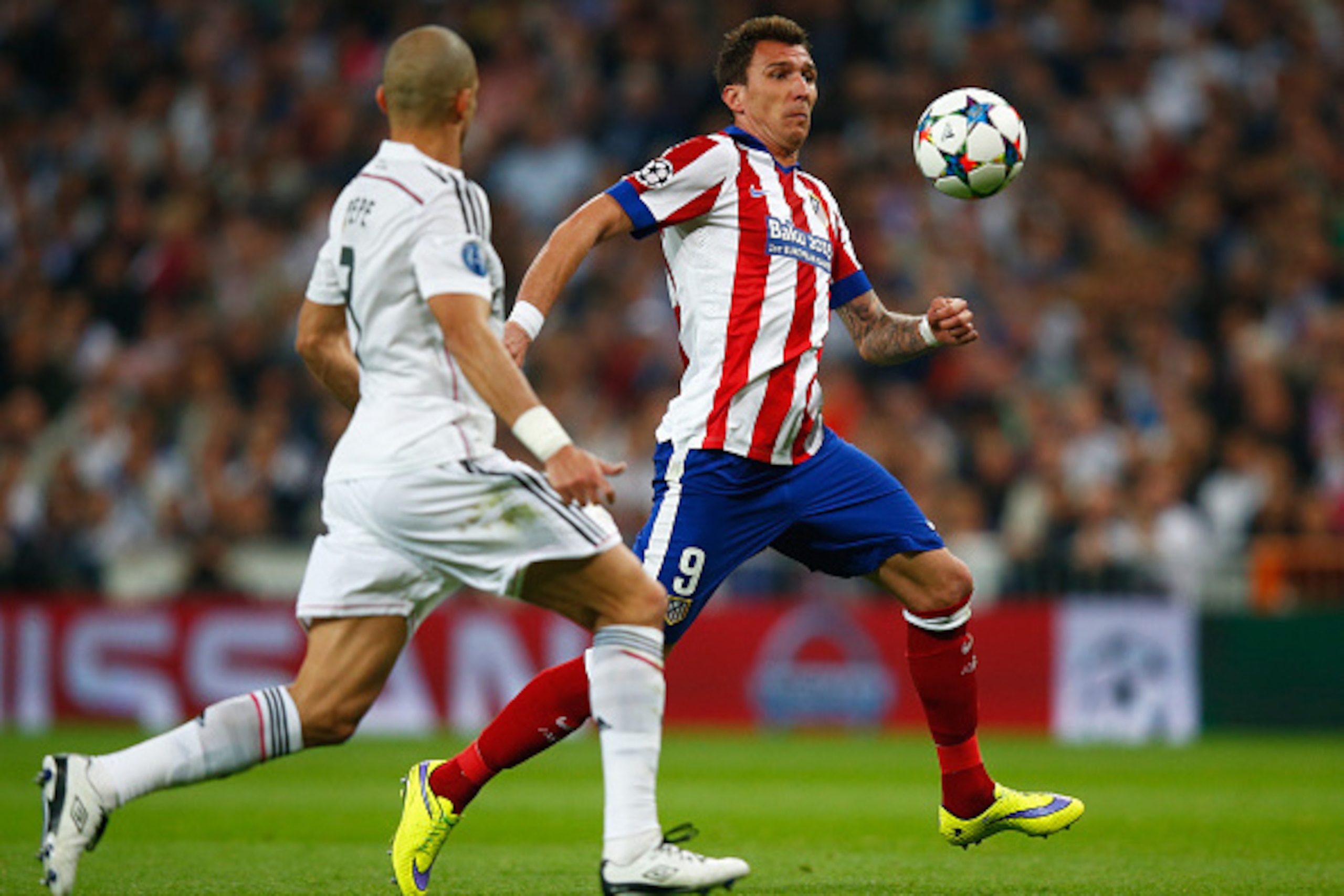 MADRID, SPAIN - APRIL 22:  Mario Mandzukic of Atletico Madrid takes on Pepe of Real Madrid CF during the UEFA Champions League quarter-final second leg match between Real Madrid CF and Club Atletico de Madrid at Bernabeu on April 22, 2015 in Madrid, Spain