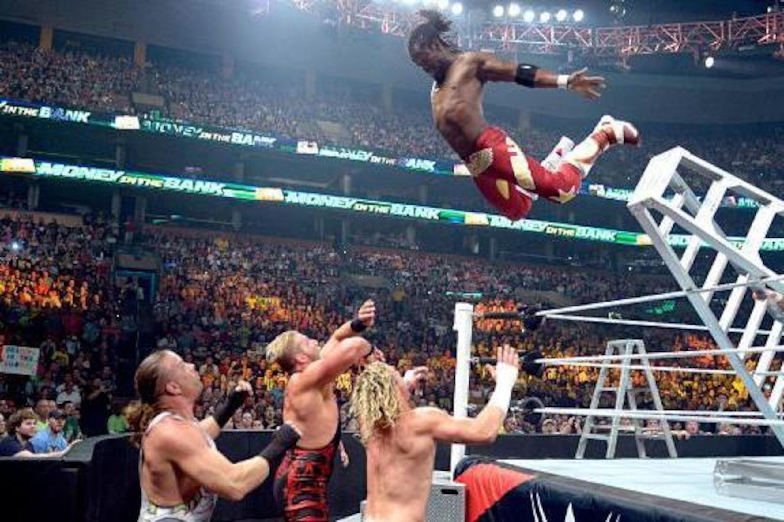 Kofi Kingston leaps from a ladder.