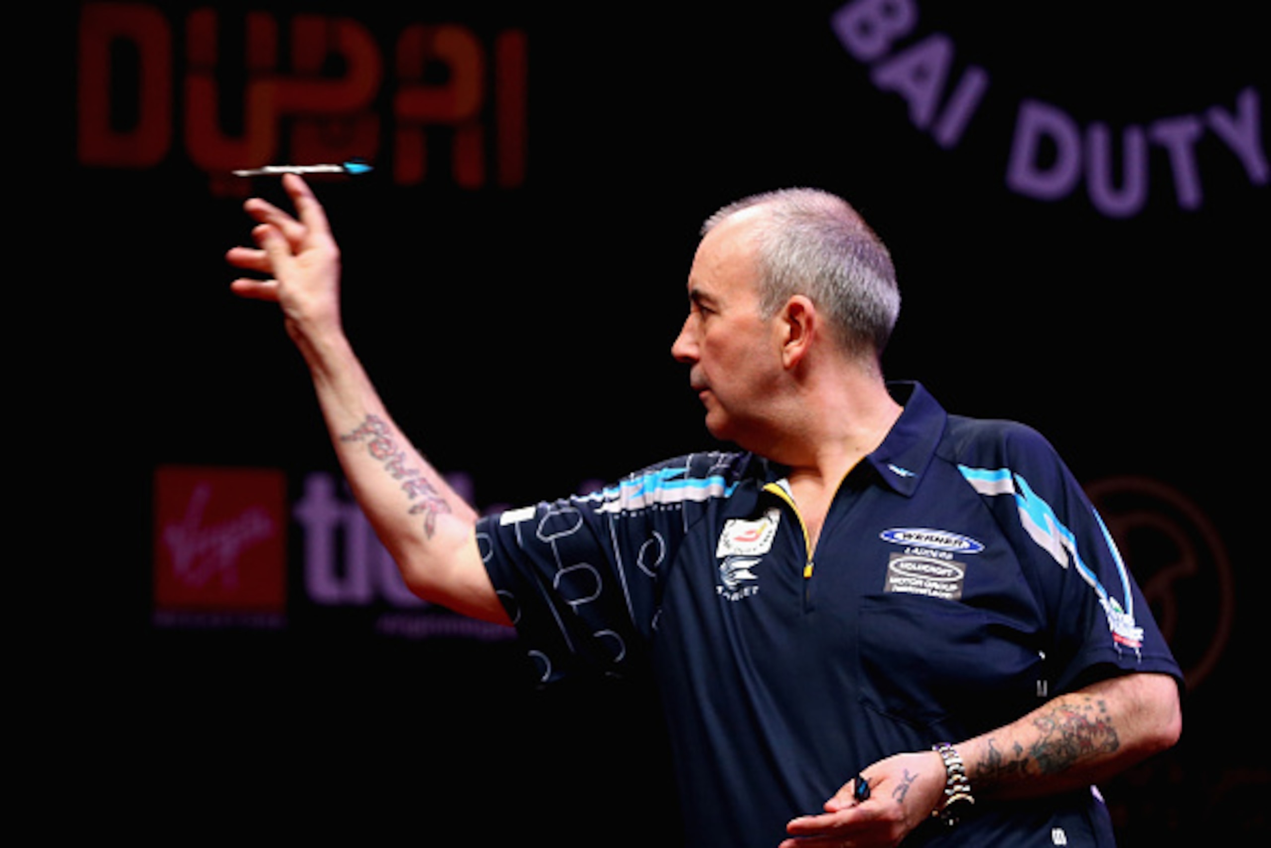DUBAI, UNITED ARAB EMIRATES - MAY 29: Phil Taylor of England in action against Michael Van Gerwen of the Netherlands during the 2015 Dubai Duty Free Darts Masters Final match at Dubai Duty Free Tennis Stadium on May 29, 2015 in Dubai, United Arab Emirates
