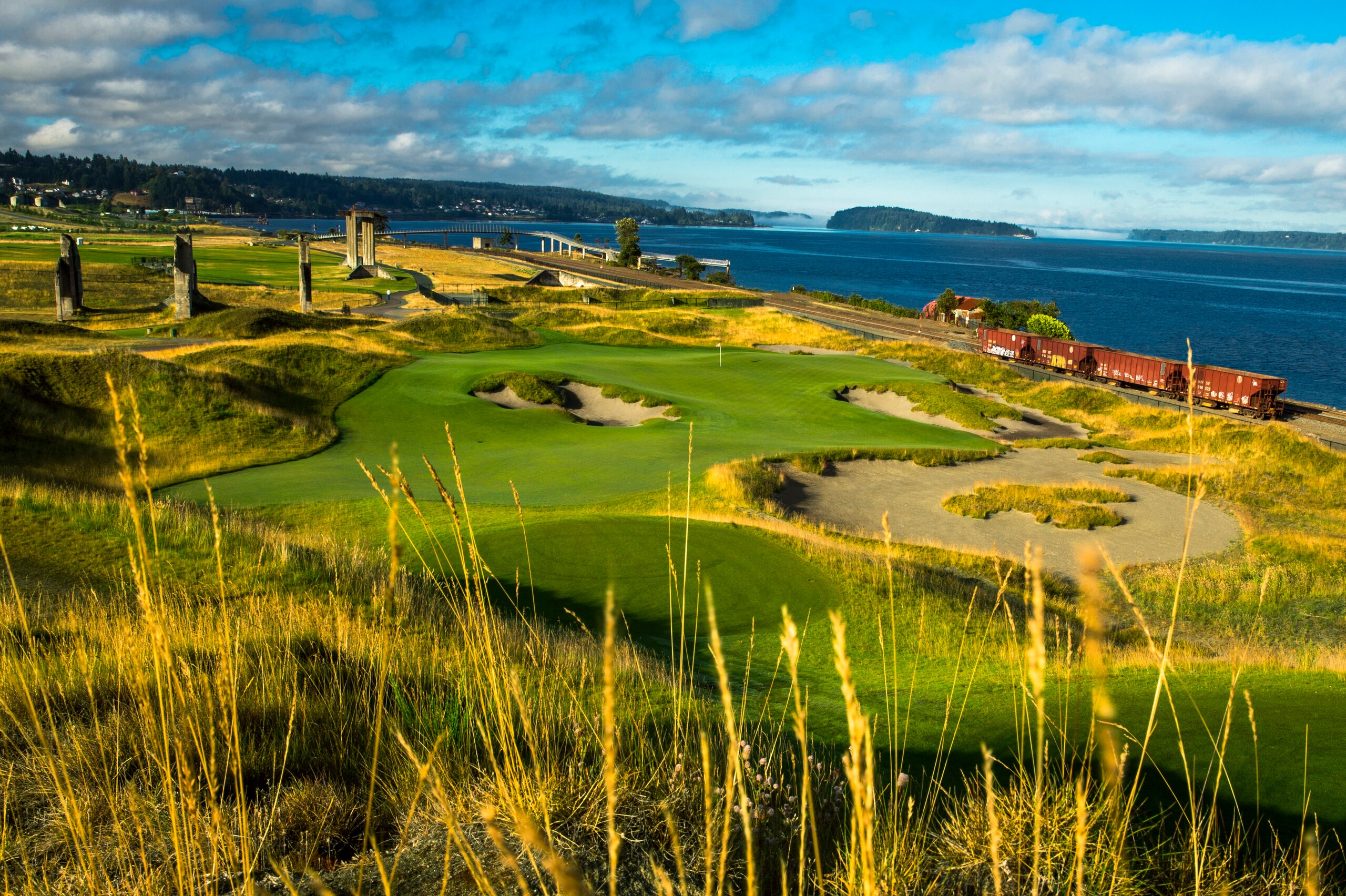 Concrete structures left from gravel mining frame the 17th hole.  Puget Sound in background.