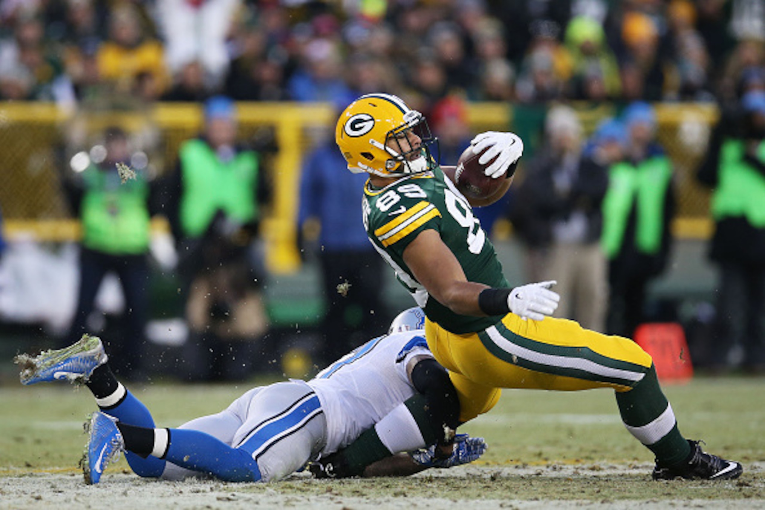 GREEN BAY, WI - DECEMBER 28:   Glover Quin #27 of the Detroit Lions tackles  Richard Rodgers #89 of the Green Bay Packers as he completes a first down at Lambeau Field on December 28, 2014 in Green Bay, Wisconsin.  (Photo by Chris Graythen/Getty Images)
