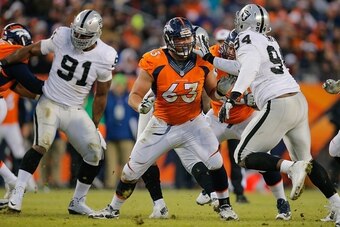 DENVER, CO - DECEMBER 28:  Guard Ben Garland #63 of the Denver Broncos blocks against defensive tackle Antonio Smith #94 of the Oakland Raiders during a game at Sports Authority Field at Mile High on December 28, 2014 in Denver, Colorado.  (Photo by Doug 