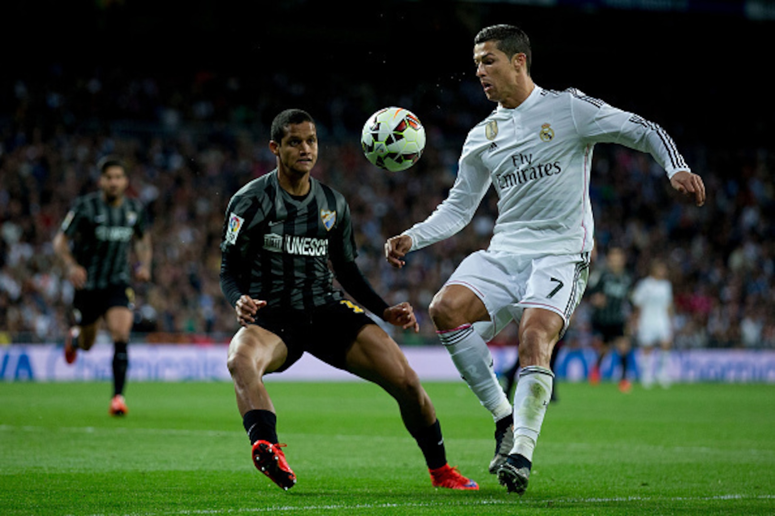 MADRID, SPAIN - APRIL 18: Cristiano Ronaldo (R) of Real Madrid CF competes for the ball with Roberto Rosales (L) of Malaga CF during the La Liga match between Real Madrid CF and Malaga CF at Estadio Santiago Bernabeu on April 18, 2015 in Madrid, Spain. MADRID, SPAIN - APRIL 18: Cristiano Ronaldo (R) of Real Madrid CF competes for the ball with Roberto Rosales (L) of Malaga CF during the La Liga match between Real Madrid CF and Malaga CF at Estadio Santiago Bernabeu on April 18, 2015 in Madrid, Spain.