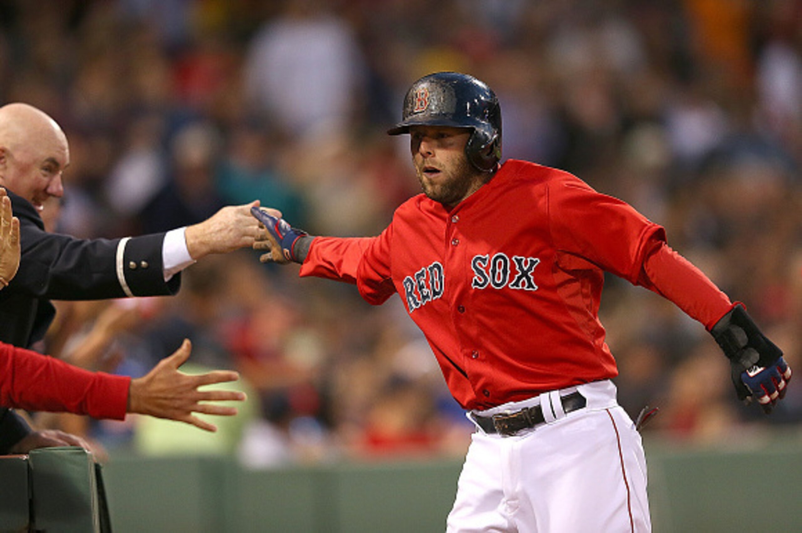 BOSTON, MA - JUNE 5:  Dustin Pedroia #15 of the Boston Red Sox celebrates with a fan after he scored a run in the fifth  inning against the Oakland Athletics at Fenway Park on June 5, 2015 in Boston, Massachusetts.  (Photo by Jim Rogash/Getty Images)