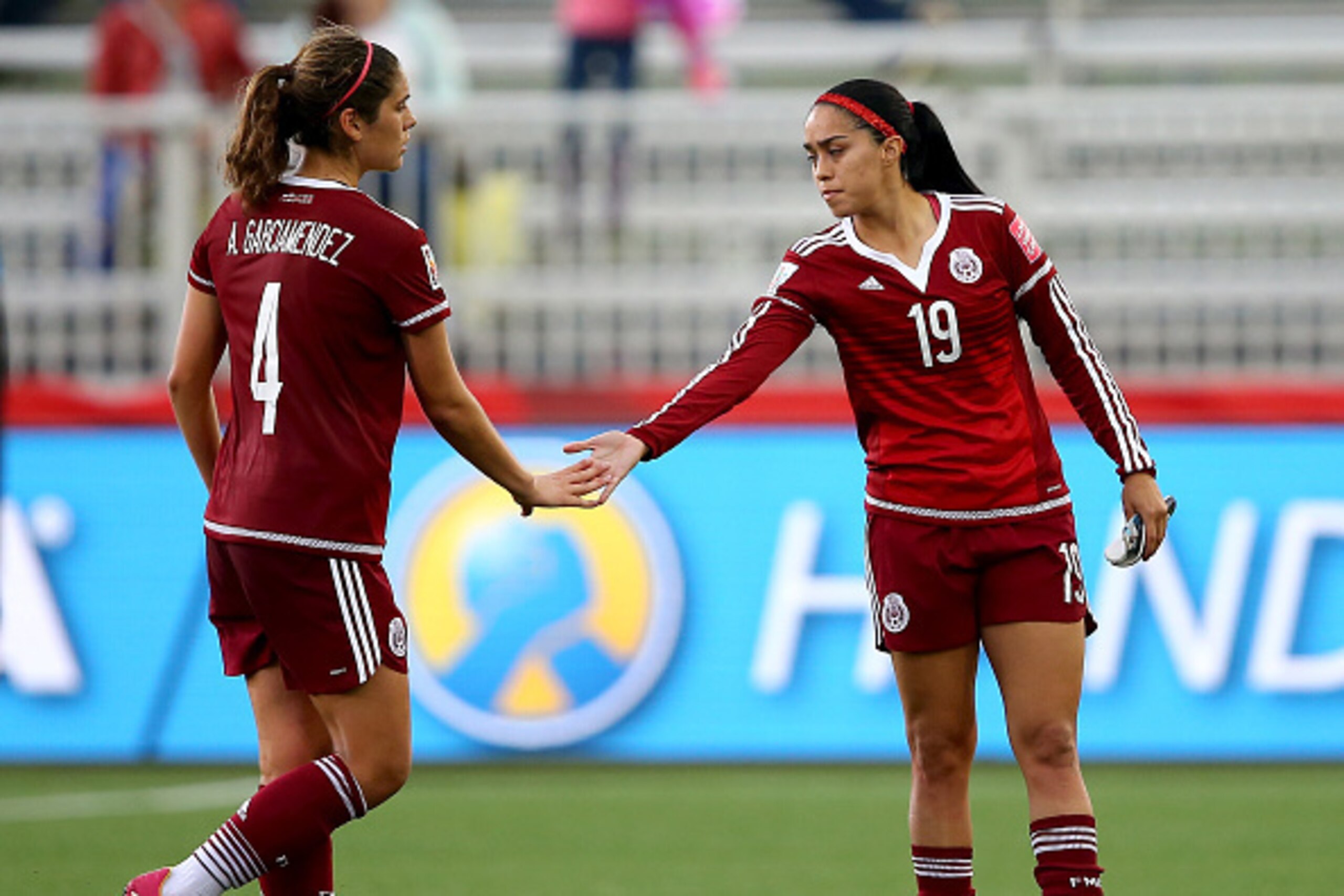 MONCTON, NB - JUNE 09: Alina Garciamendez #4 and Renae Cuellar #19 of Mexico console each other after the match against Colombia during the FIFA Women's World Cup 2015 Group F match at Moncton Stadium on June 9, 2015 in Moncton, Canada.Mexico and Colombia