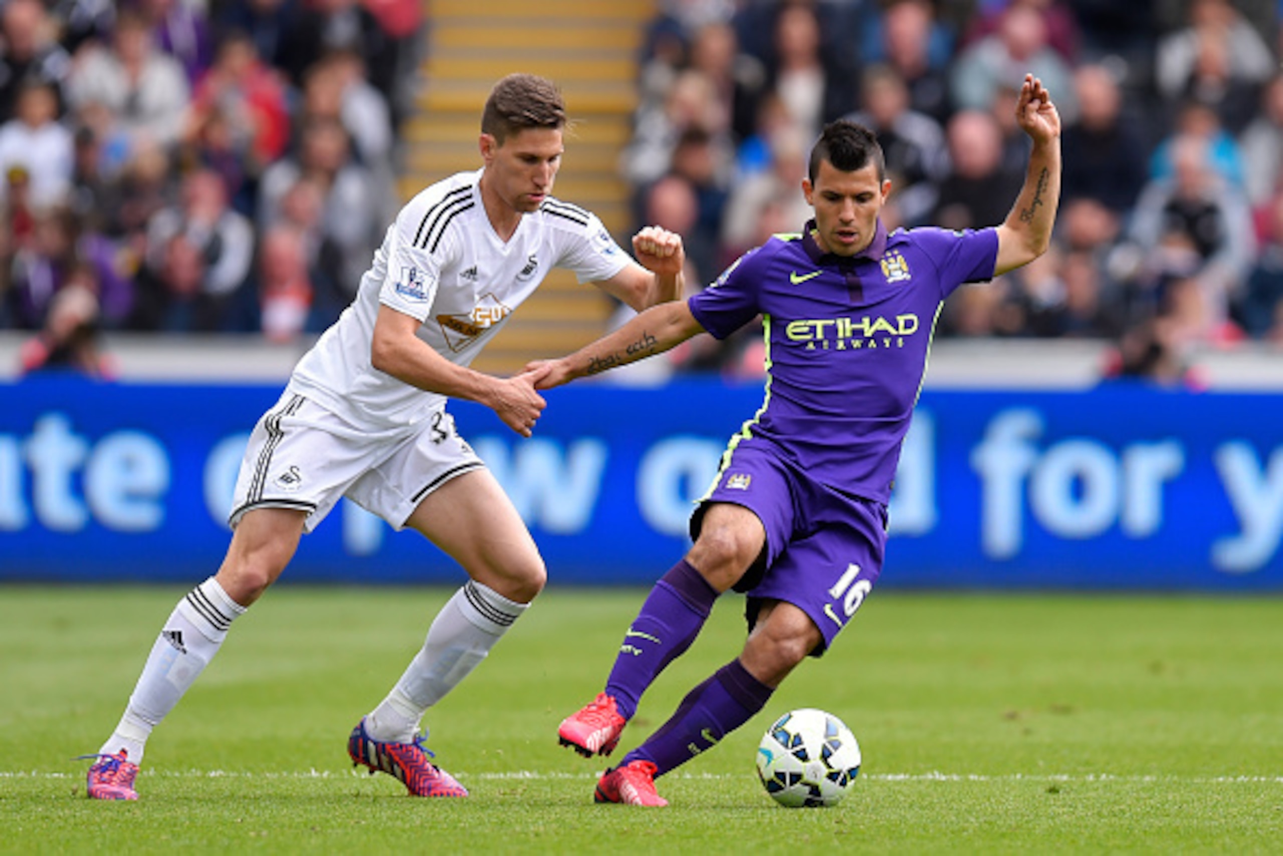 SWANSEA, WALES - MAY 17:  Sergio Aguero of Manchester City is challenged by Federico Fernandez of Swansea City during the Barclays Premier League match between Swansea and Manchester City at the Liberty Stadium on May 17, 2015 in Swansea, Wales.  (Photo b