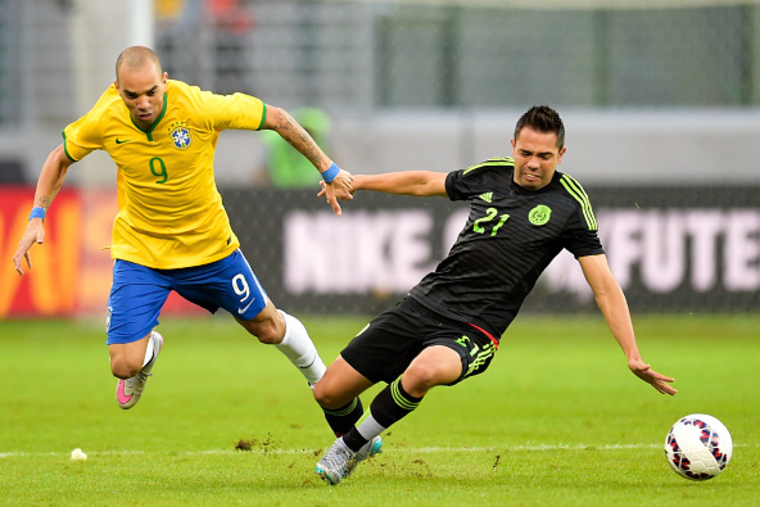 SAO PAULO, BRAZIL - JUNE 07: Diego Tardelli #9 of Brazil and George Corral #21 of Mexico compete for the ball during the International Friendly Match between Brazil and Mexico at Allianz Parque on June 7, 2015 in Sao Paulo, Brazil.  (Photo by Buda Mendes/