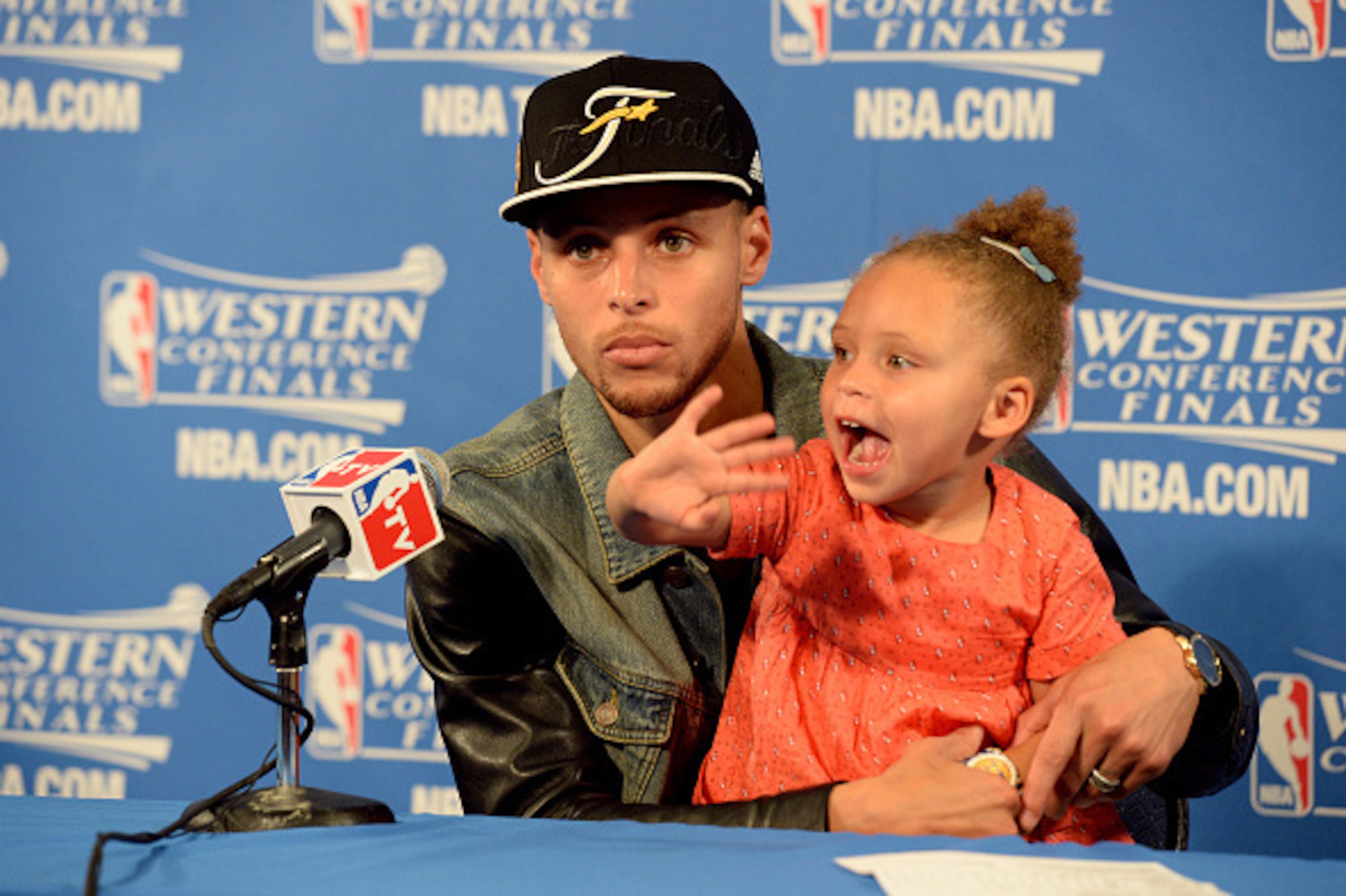 OAKLAND, CA - MAY 27: Stephen Curry #30 of the Golden State Warriors speaks to the media with daughter Riley Curry after a game against the Houston Rockets in Game Five of the Western Conference Finals during the 2015 NBA Playoffs on May 27, 2015 at ORACL OAKLAND, CA - MAY 27: Stephen Curry #30 of the Golden State Warriors speaks to the media with daughter Riley Curry after a game against the Houston Rockets in Game Five of the Western Conference Finals during the 2015 NBA Playoffs on May 27, 2015 at ORACL