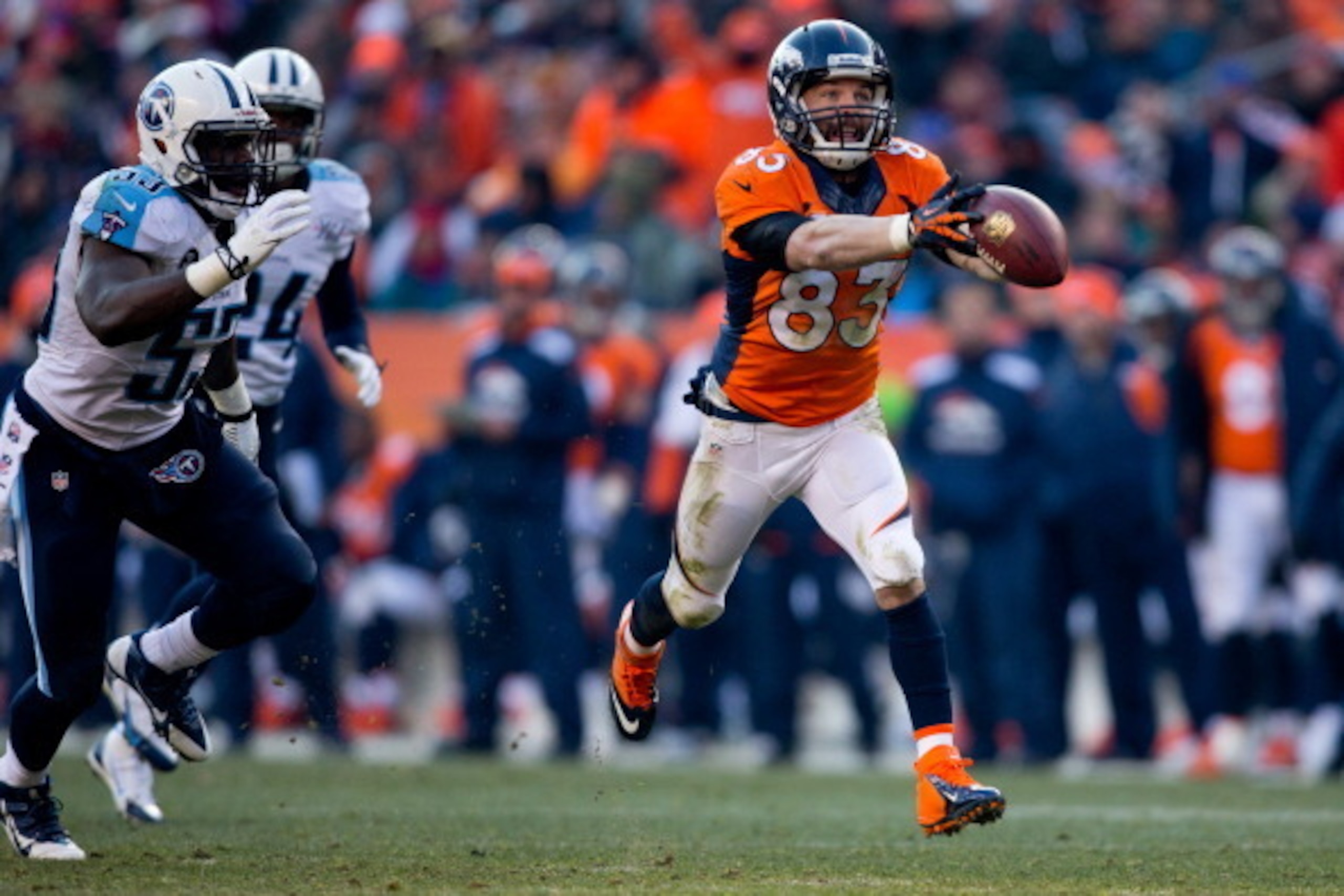 DENVER, CO - DECEMBER 8:  Wide receiver Wes Welker #83 of the Denver Broncos catches a pass against linebacker Moise Fokou #53 of the Tennessee Titans during the second quarter at Sports Authority Field Field at Mile High on December 8, 2013 in Denver, Co