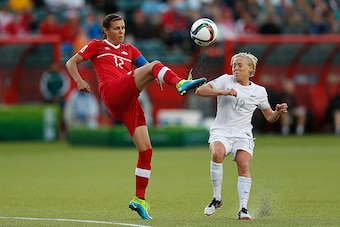 EDMONTON, AB - JUNE 11: Christine Sinclair (L) of Canada kicks the ball in front of Betsy Hassett of New Zealand during the FIFA Women's World Cup Canada Group A match between Canada and New Zealand at Commonwealth Stadium on June 11, 2015 in Edmonton, Al