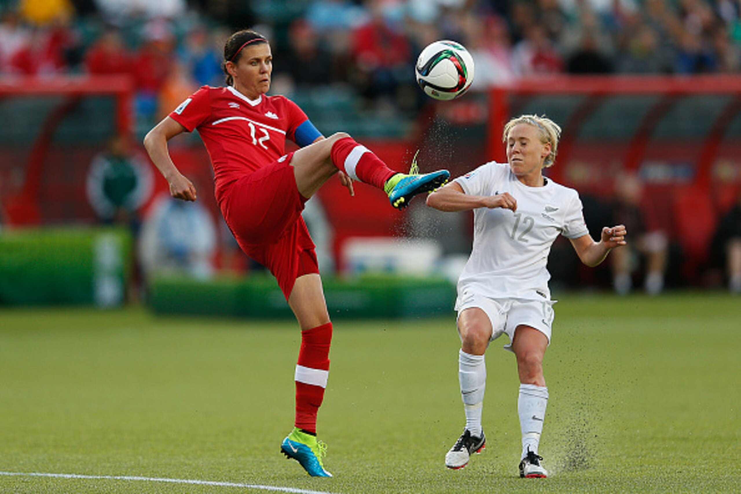 EDMONTON, AB - JUNE 11: Christine Sinclair (L) of Canada kicks the ball in front of Betsy Hassett of New Zealand during the FIFA Women's World Cup Canada Group A match between Canada and New Zealand at Commonwealth Stadium on June 11, 2015 in Edmonton, Al