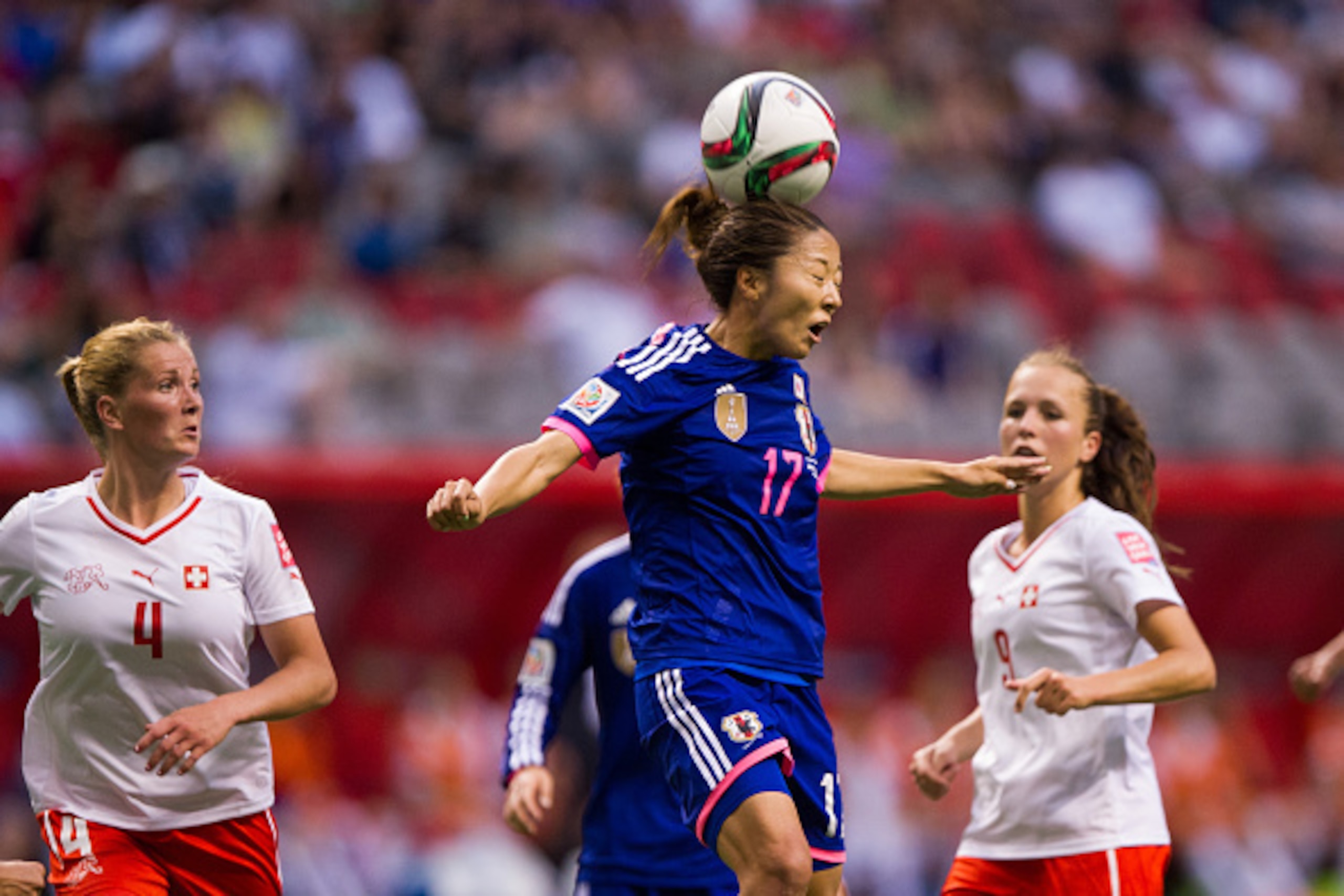 VANCOUVER, BC - MAY 8:  Yuki Ogimi of #17 Japan gets her head on the ball while Lia Walti #9 and Rachel Rinast #4 of Switzerland look on during the FIFA Women's World Cup Canada 2015 Group C match between Japan and Switzerland June, 8, 2015 at BC Place St