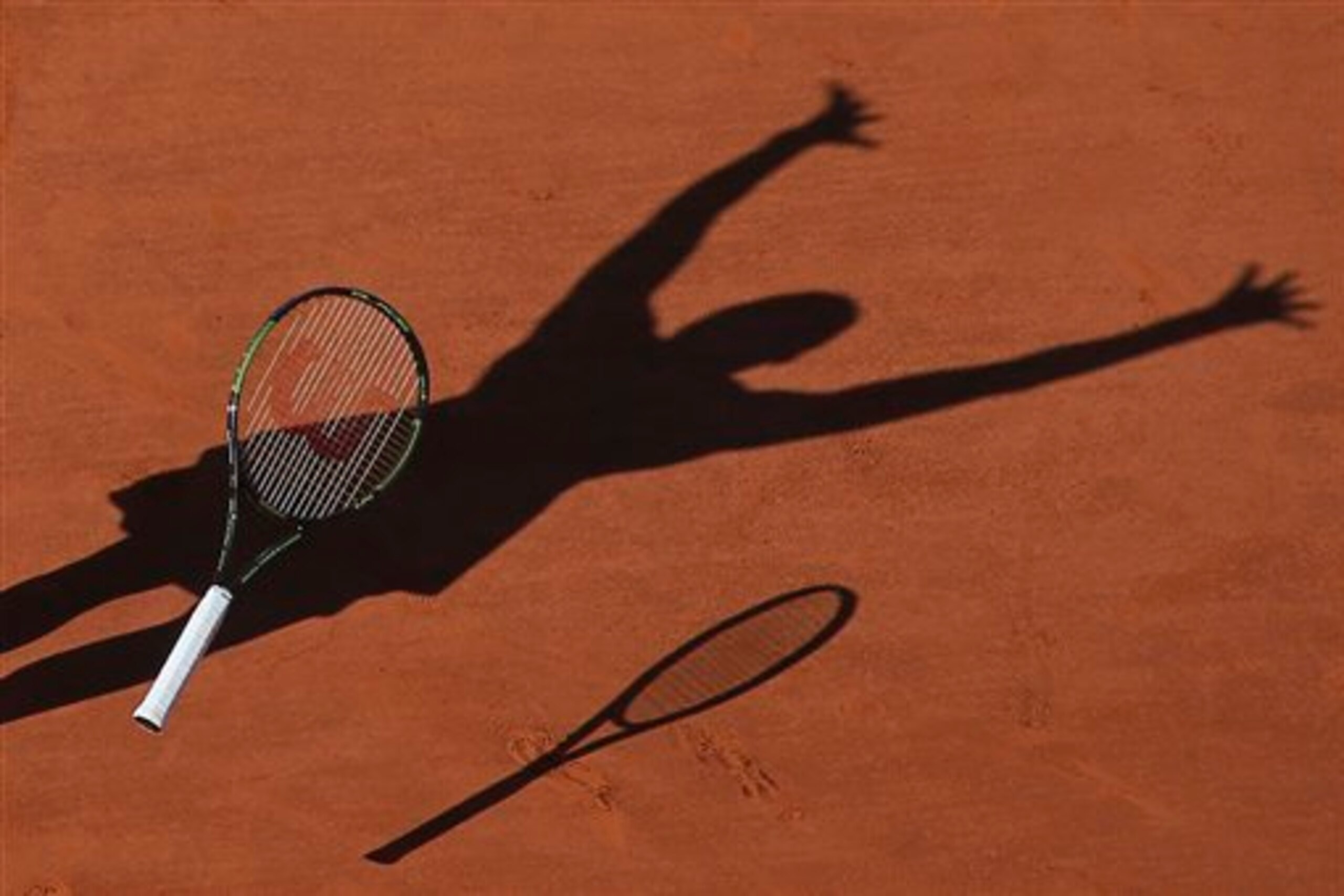 The shadow of Serena Williams as she throws her racket to celebrate winning the 2015 French Open. The shadow of Serena Williams as she throws her racket to celebrate winning the 2015 French Open.