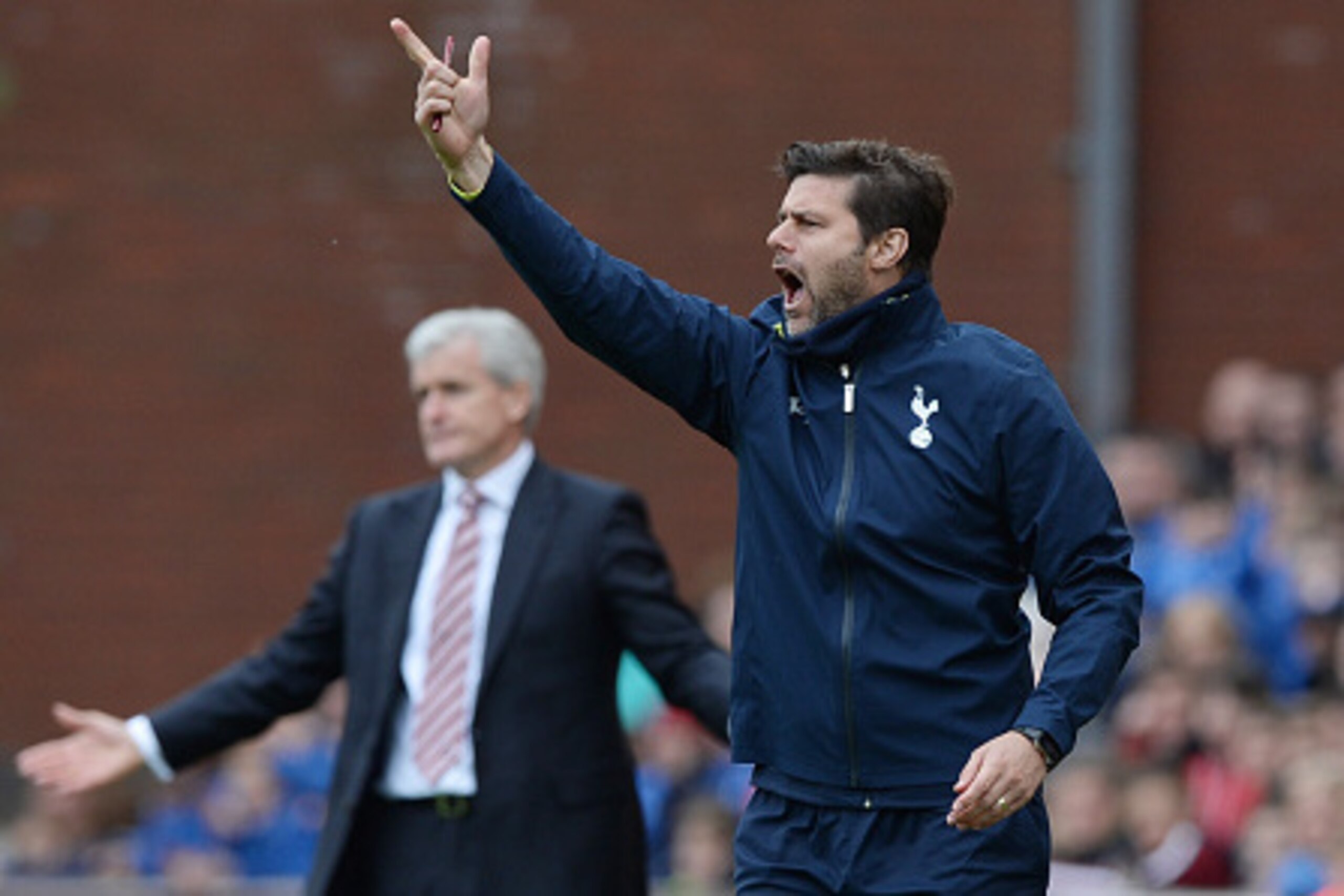 STOKE ON TRENT, ENGLAND - MAY 09:  Mauricio Pochettino manager of Spurs reacts as Mark Hughes manager of Stoke City looks on during the Barclays Premier League match between Stoke City and Tottenham Hotspur at Britannia Stadium on May 9, 2015 in Stoke on 
