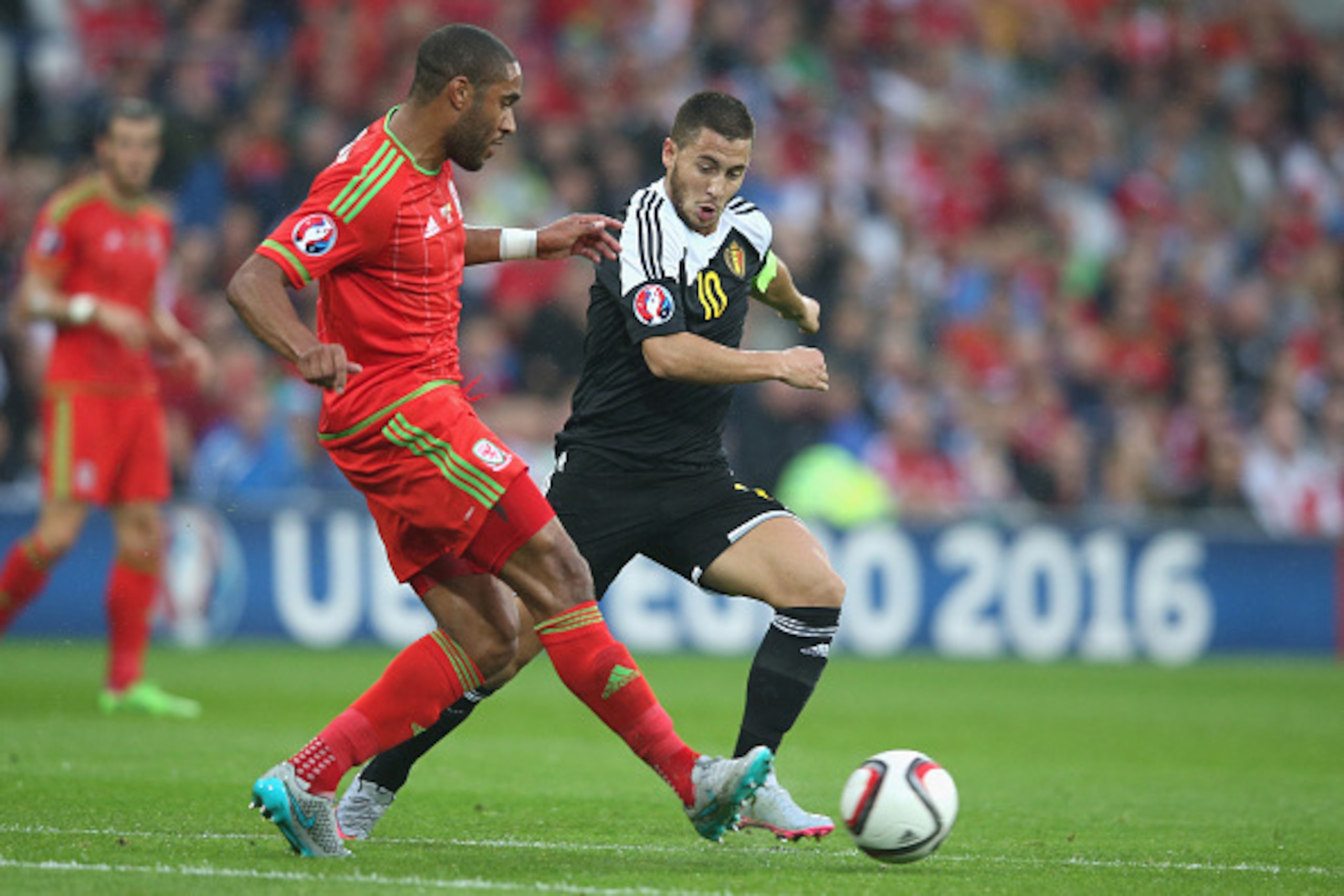 CARDIFF, WALES - JUNE 12:  Ashley Williams of Wales clears the ball was Eden Hazard challenges during the UEFA EURO 2016 qualifying match between Wales and Belgium at the Cardiff City Stadium on June 12, 2015 in Cardiff, United Kingdom.  (Photo by David R