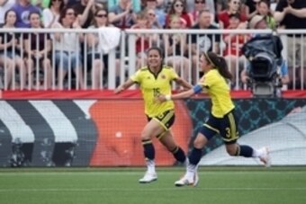 Jun 13, 2015; Moncton, New Brunswick, CAN; Colombia forward Lady Andrade (16) celebrates with Colombia midfielder Natalia Gaitan (3) after scoring a goal during the first half against France in a Group F soccer match in the 2015 FIFA women's World Cup at