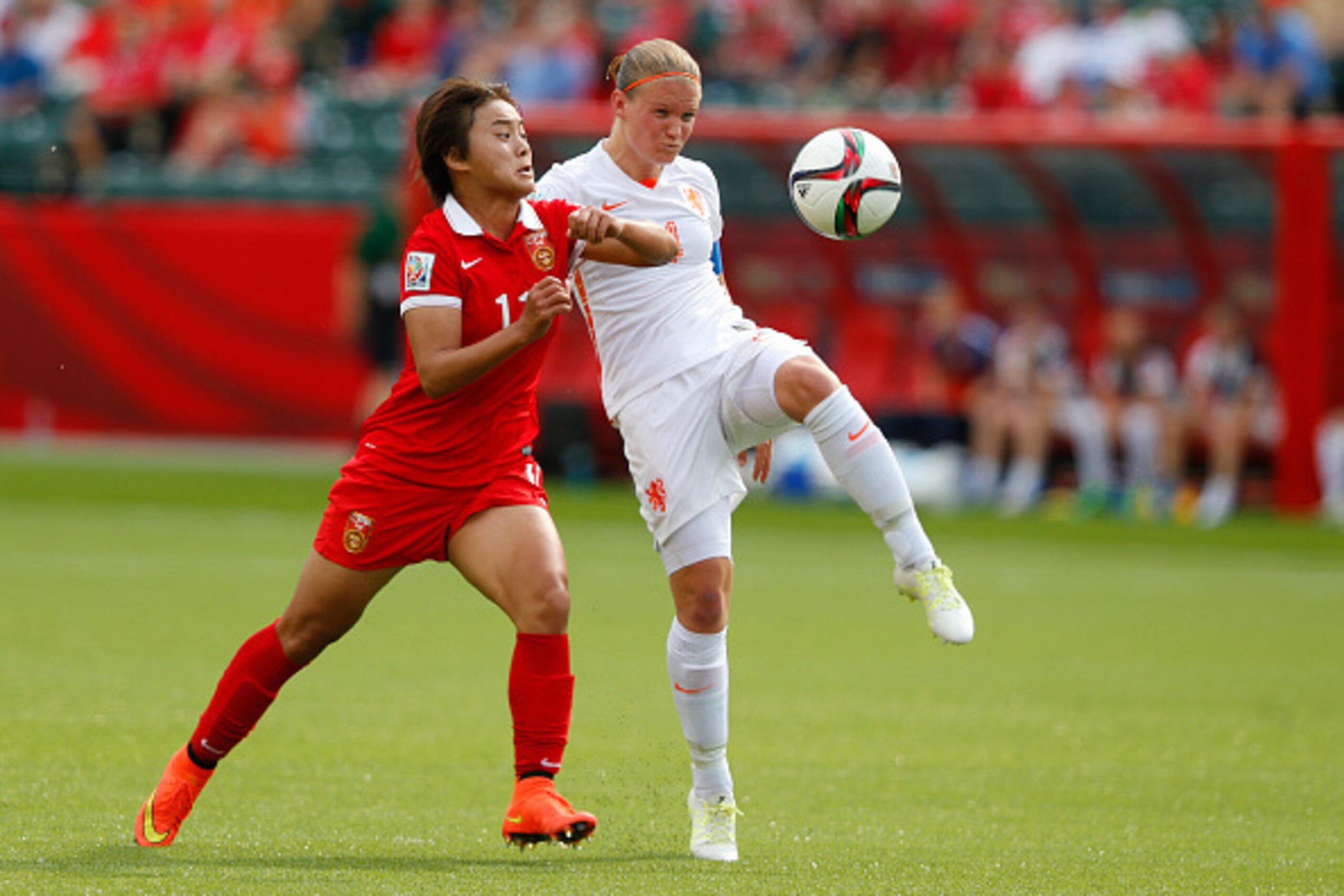 EDMONTON, AB - JUNE 11: Wang Shuang #11 of China and Mandy Van Den Berg #4 of Netherlands battle for the ball during the FIFA Women's World Cup Canada Group A match between China and Netherlands at Commonwealth Stadium on June 11, 2015 in Edmonton, Albert