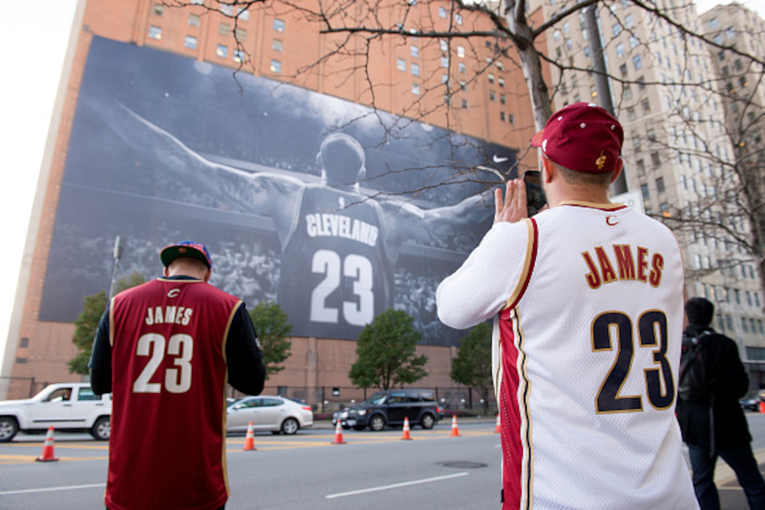 CLEVELAND, OH - OCTOBER 30: Fans take pictures of a LeBron James #23 of the Cleveland Cavaliers banner outside Quicken Loans Arena before a game against the New York Knicks on October 30, 2014 in Cleveland, Ohio. NOTE TO USER: User expressly acknowledges