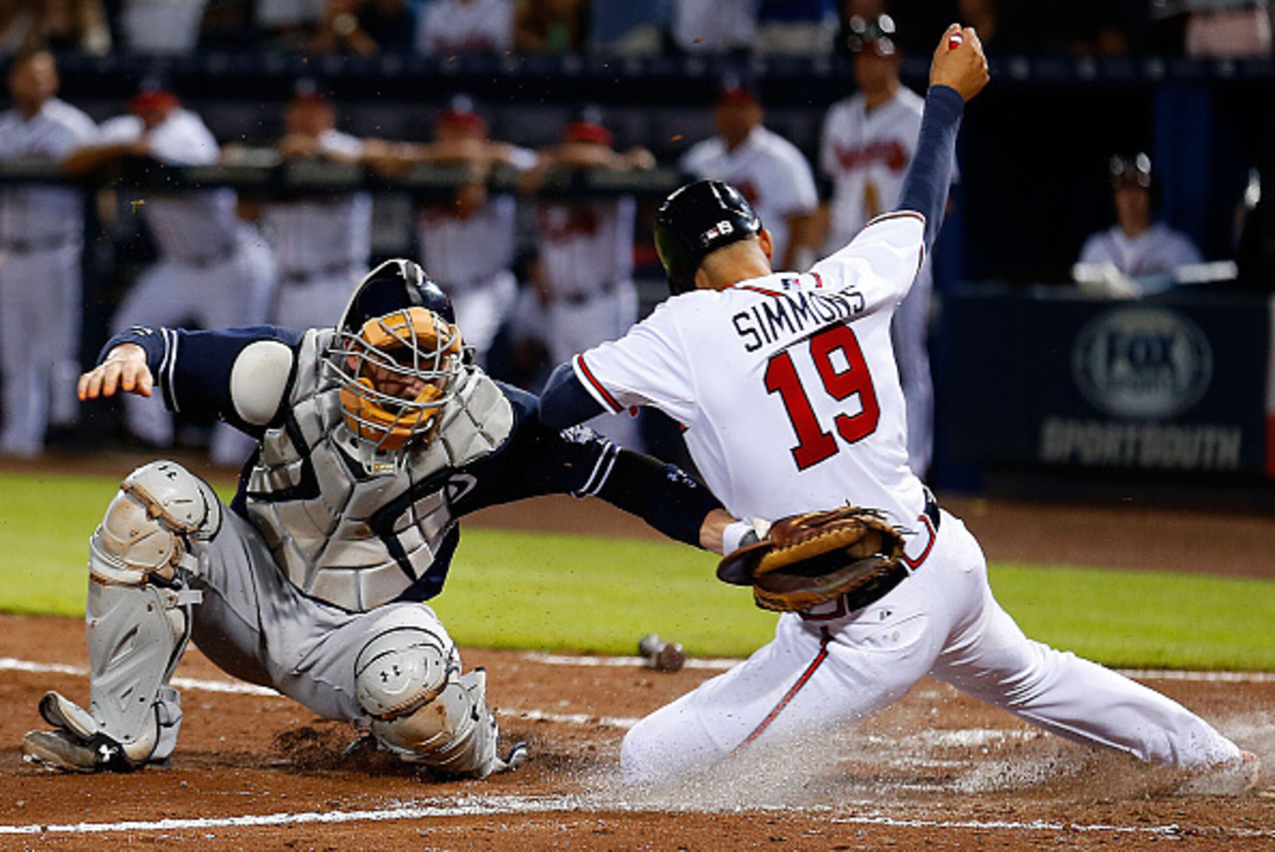 ATLANTA, GA - JUNE 09:  Shortstop Andrelton Simmons #19 of the Atlanta Braves slides behind catcher Derek Norris #3 of the San Diego Padres in the sixth inning to score the tying run during the game at Turner Field on June 9, 2015 in Atlanta, Georgia.  (P