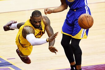 CLEVELAND, OH - JUNE 11:  LeBron James #23 of the Cleveland Cavaliers falls to the court as Andre Iguodala #9 of the Golden State Warriors defends in the first quarter during Game Four of the 2015 NBA Finals at Quicken Loans Arena on June 11, 2015 in Clev