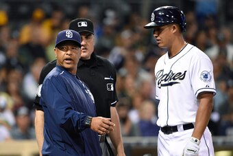 SAN DIEGO, CA - JUNE 15:  Interim manager Dave Roberts #8 of the San Diego Padres argues a call with home plate umpire Mike DiMuro as Will Venable #25 looks on during the third inning of a baseball game against the Oakland Athletics at Petco Park June 15,