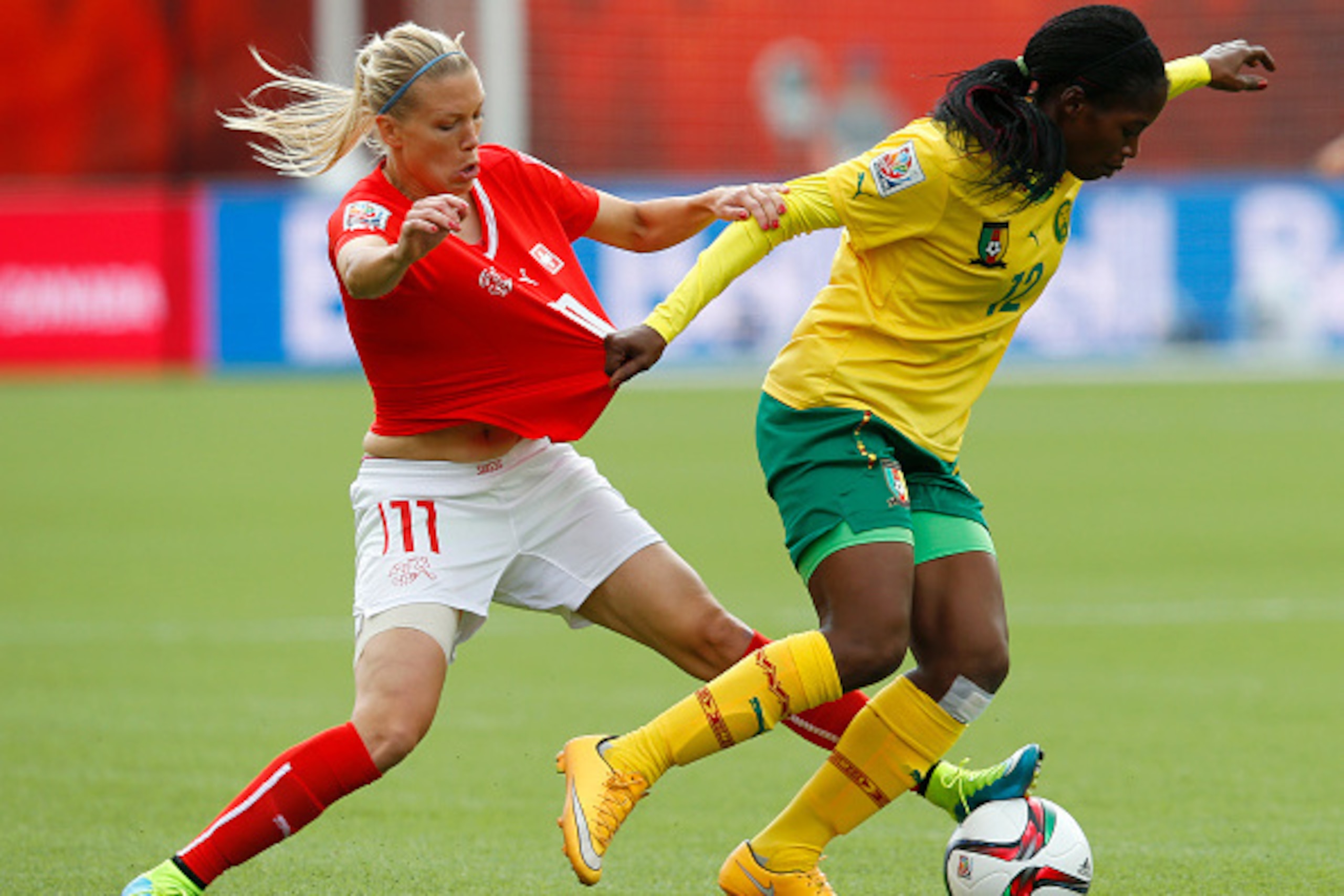 EDMONTON, AB - JUNE 16: Lara Dickenmann #11 of Switzerland and Claudine Meffometou Tcheno #12 of Cameroon battle for the ball during the FIFA Women's World Cup Canada Group C match between Switzerland and Cameroon at Commonwealth Stadium on June 16, 2015 