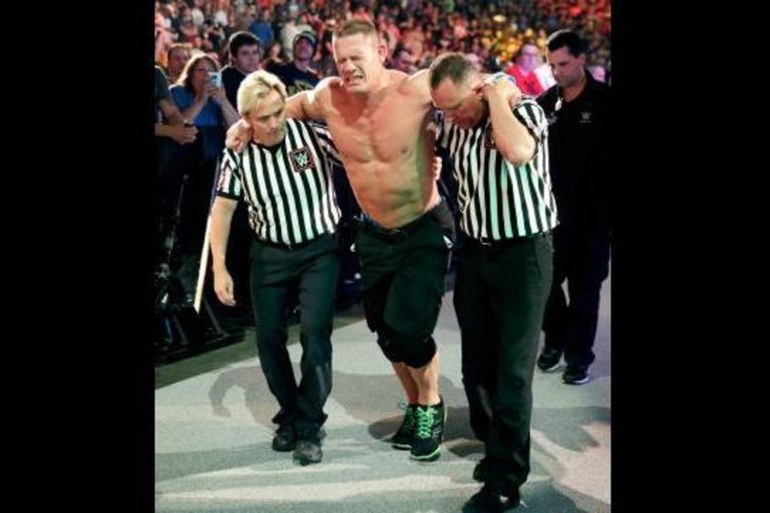 John Cena suffering the aftereffects of Kevin Owens assaulting him.