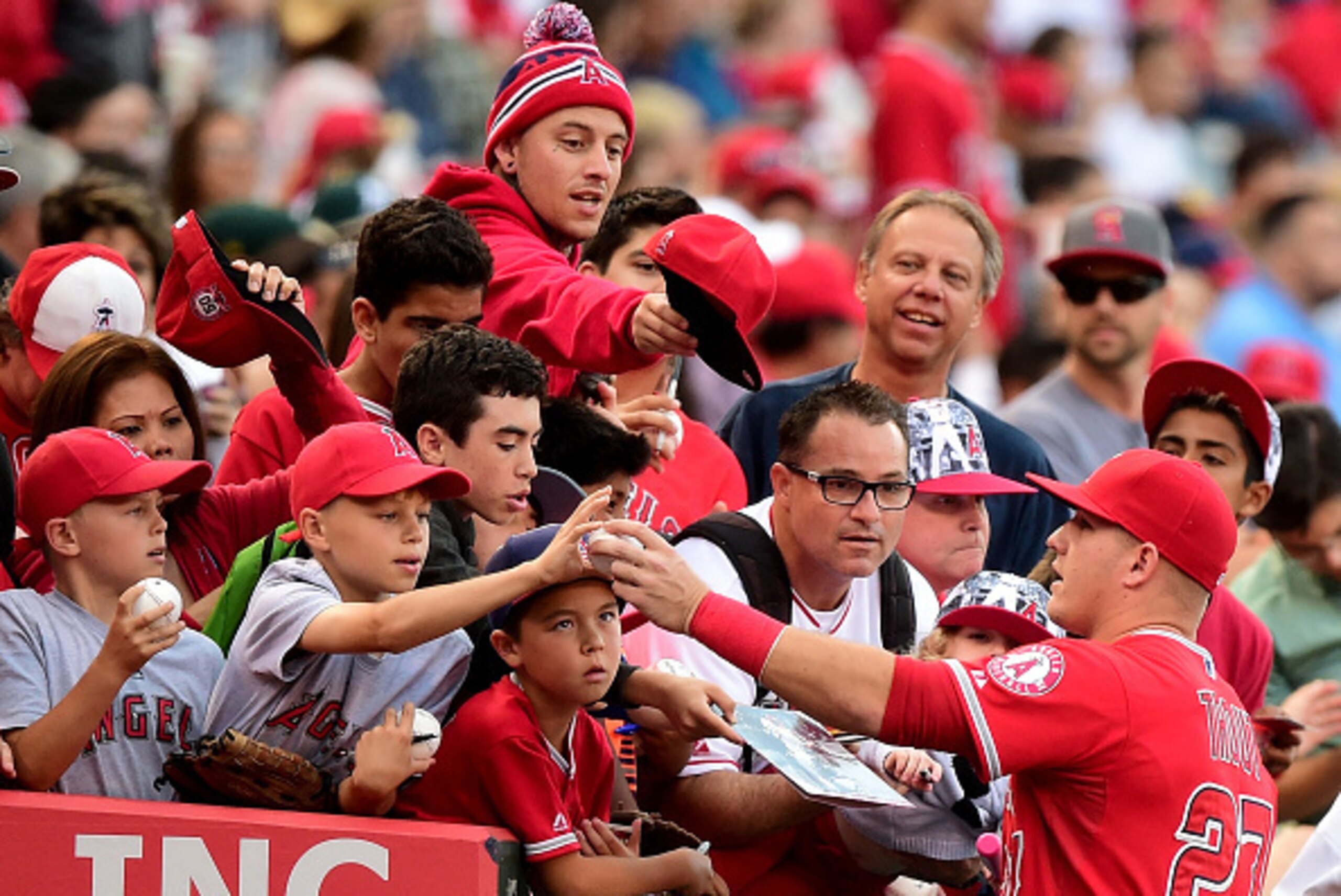 ANAHEIM, CA - JUNE 13:  Mike Trout #27 of the Los Angeles Angels signs autographs for fans before the game against the Oakland Athletics at Angel Stadium of Anaheim on June 13, 2015 in Anaheim, California.  (Photo by Harry How/Getty Images)