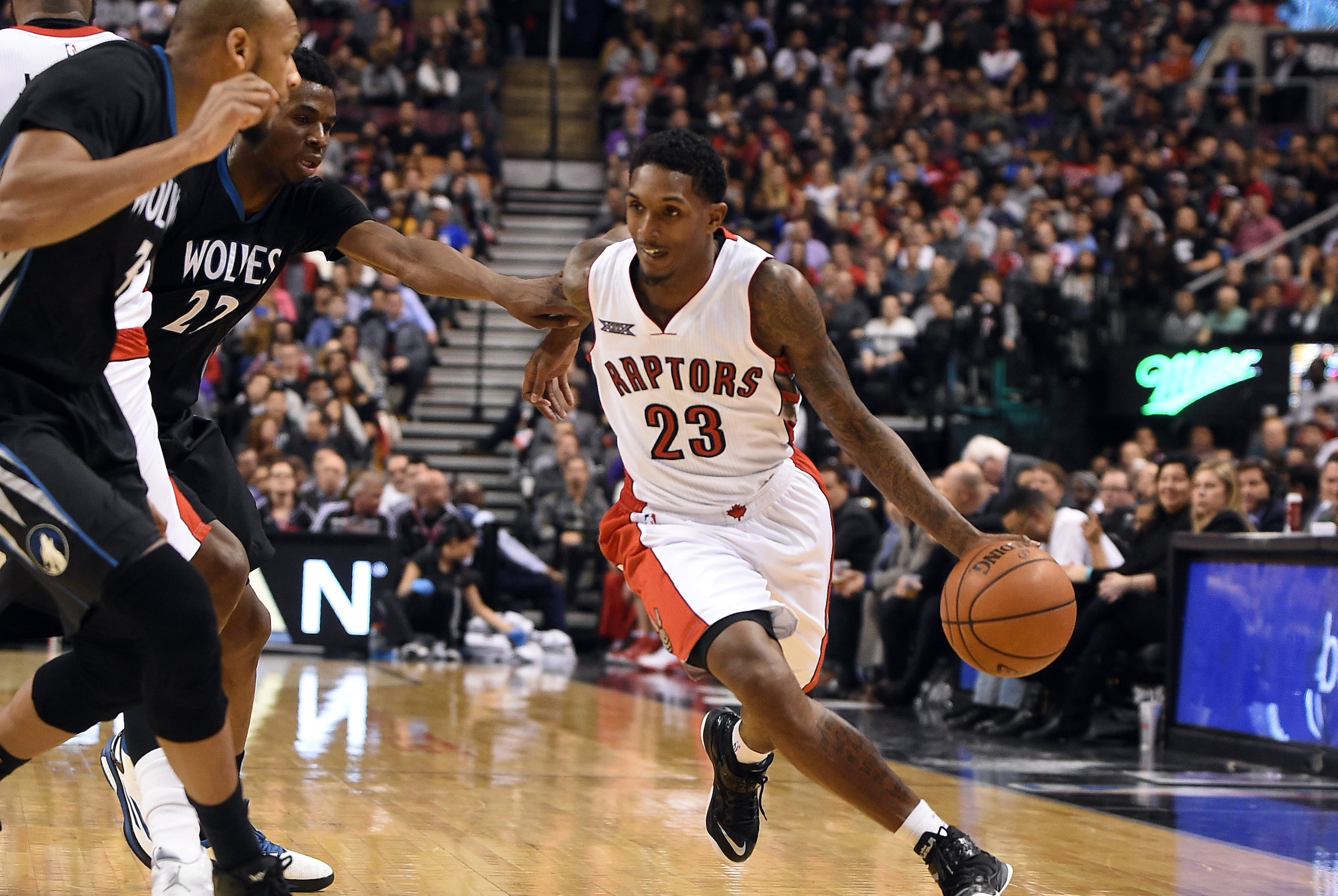 Mar 18, 2015; Toronto, Ontario, CAN;  Toronto Raptors guard Lou Williams (23) dribbles past Minnesota Timberwolves forward Andrew Wiggins (22) and forward Adreian Payne (3) during the second half of the Raptors 105-100 win at Air Canada Centre. Mandatory