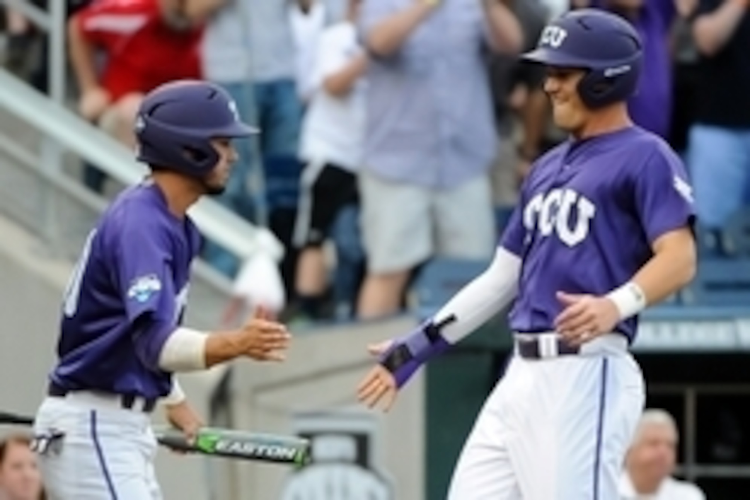 Jun 18, 2015; Omaha, NE, USA; TCU Horned Frogs infielder Derek Odell (5) and outfielder Dane Steinhagen (10) celebrate after scoring the the second inning against the LSU Tigers in the 2015 College World Series at TD Ameritrade Park. Mandatory Credit: Ste