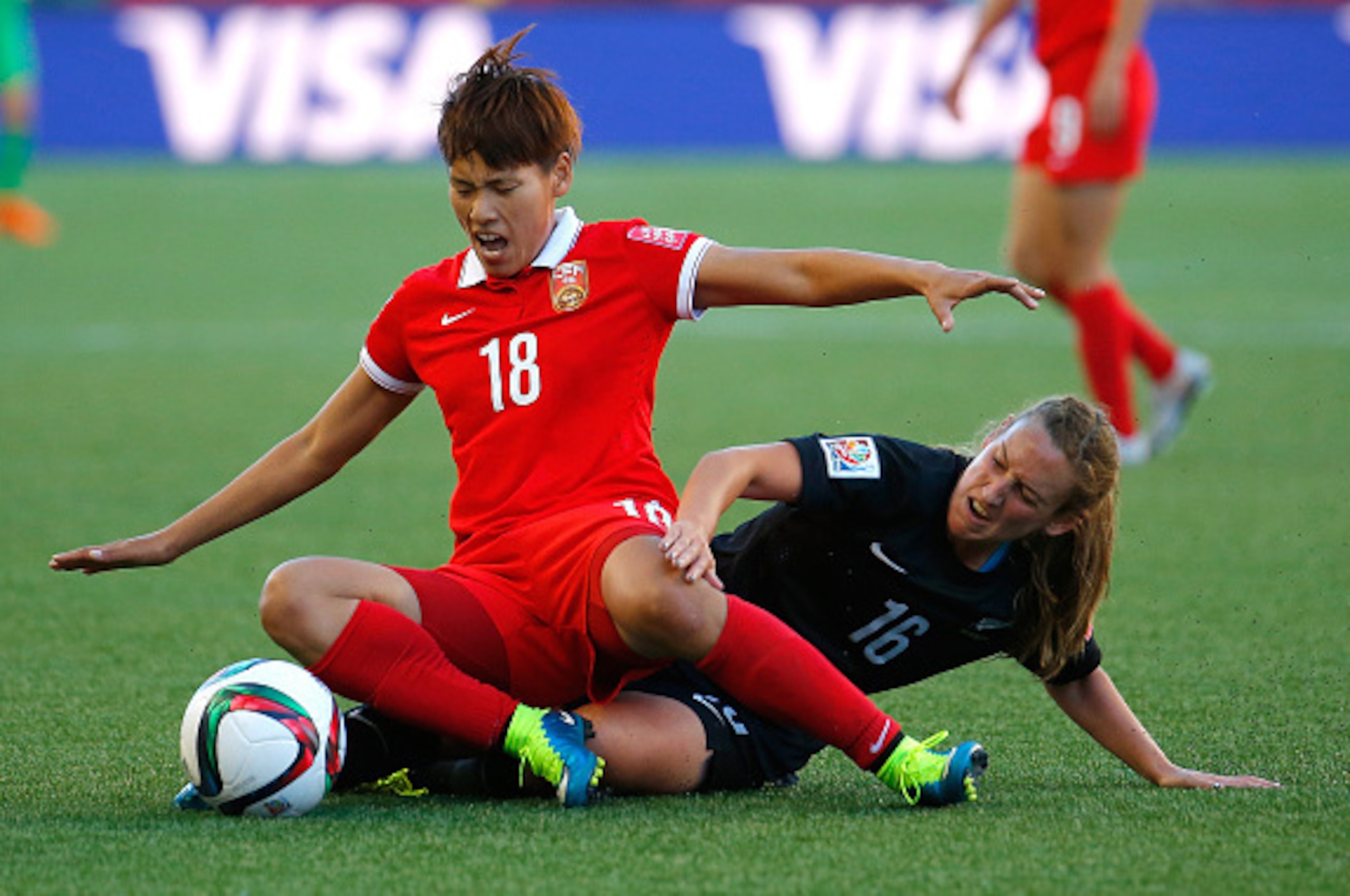 WINNIPEG, MB - JUNE 15:  Han Peng #18 of China PR challenges Annalie Longo #16 of New Zealand during the FIFA Women's World Cup Canada 2015 Group A match between China PR and New Zealand at Winnipeg Stadium on June 15, 2015 in Winnipeg, Canada.  (Photo by
