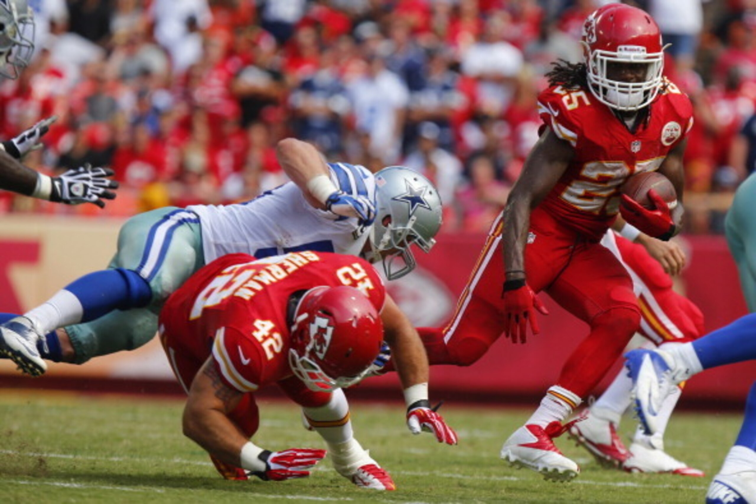 KANSAS CITY, MO - SEPTEMBER 15: Jamaal Charles #25 looks for a running lane as Anthony Sherman #42 of the Kansas City Chiefs takes out Sean Lee #50 of the Dallas Cowboys in the fourth  quarter September 15, 2013 at Arrowhead Stadium in Kansas City, Missou
