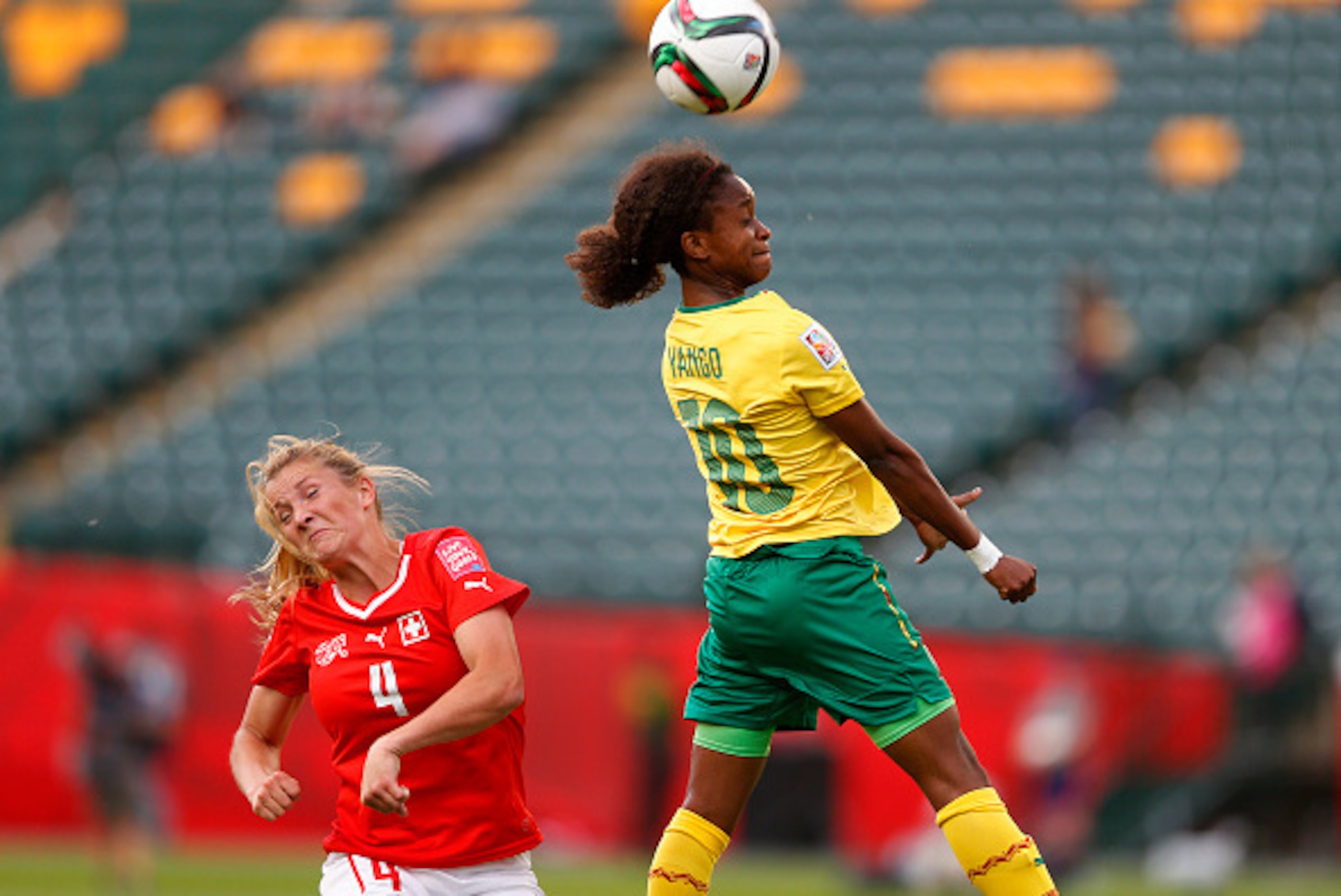 EDMONTON, AB - JUNE 16: Rachel Rinast #4 of Switzerland reacts as Jeannette Yango #10 of Cameroon heads the ball during the FIFA Women's World Cup Canada Group C match between Switzerland and Cameroon at Commonwealth Stadium on June 16, 2015 in Edmonton, 