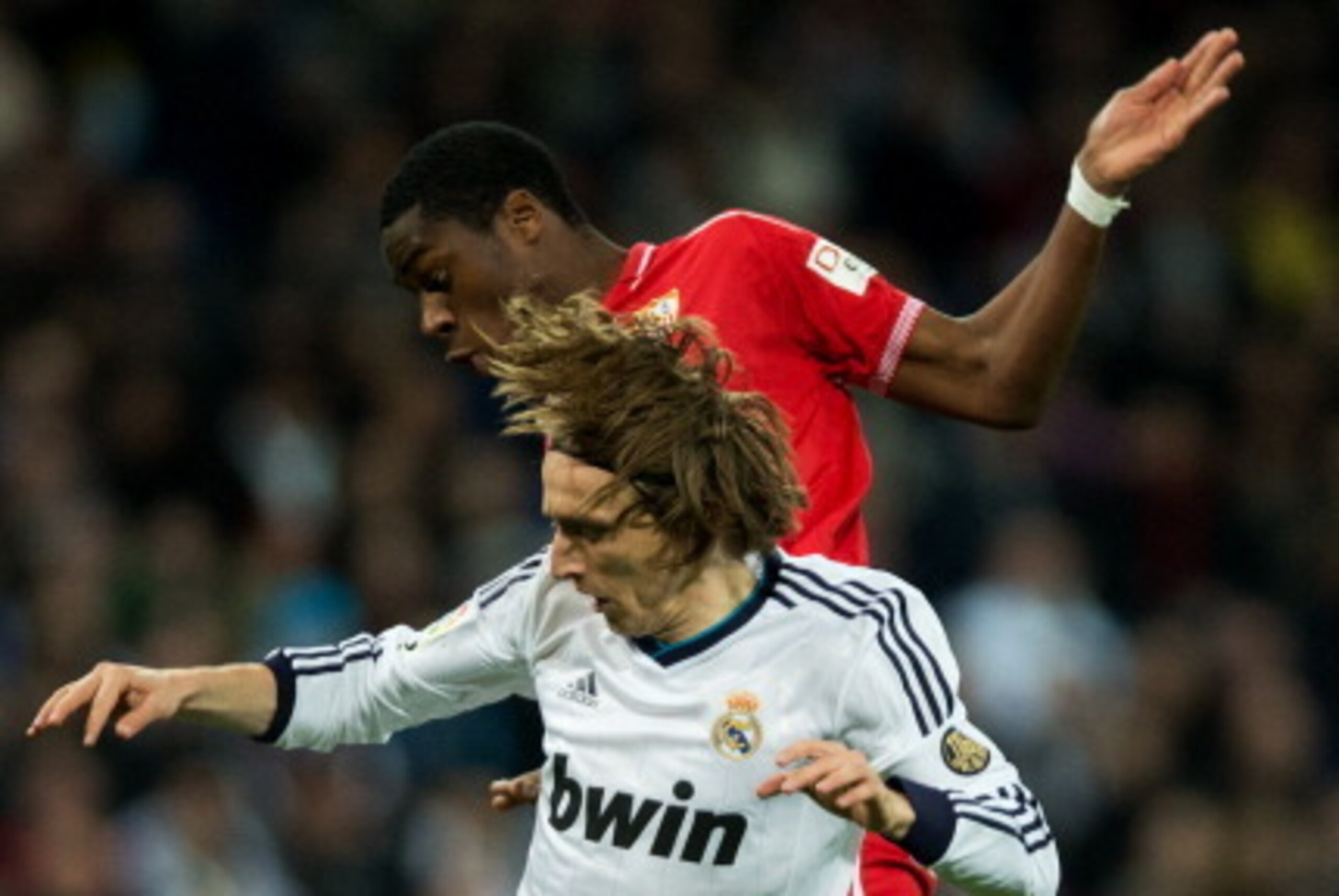 MADRID, SPAIN - FEBRUARY 09: Luka Modric (L) of Real Madrid duels for the ball with Geoffrey Kondogbia of Sevilla during the la Liga match between Real Madrid CF and Sevilla FC at Estadio Santiago Bernabeu on February 9, 2013 in Madrid, Spain.  (Photo by 