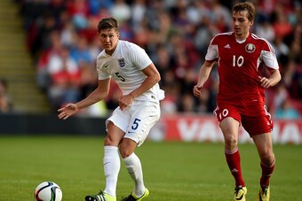 BARNSLEY, ENGLAND - JUNE 11: John Stones of England is challened by Yahuhen Lebedzeu of Belarus during the international friendly match between England U21 and Belarus U21 at Oakwell Stadium on June 11, 2015 in Barnsley, England.  (Photo by Ross Kinnaird/
