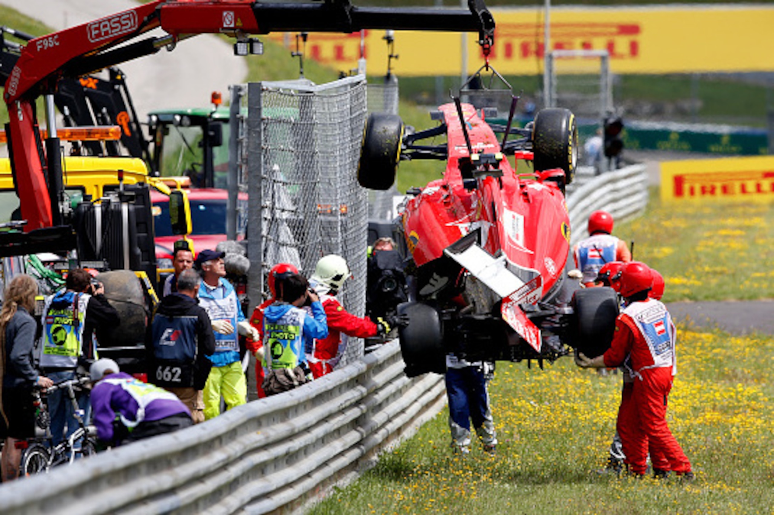 SPIELBERG, AUSTRIA - JUNE 21:  Marshalls retrieve the car of Kimi Raikkonen of Finland and Ferrari after he crashed during the Formula One Grand Prix of Austria at Red Bull Ring on June 21, 2015 in Spielberg, Austria.  (Photo by Charles Coates/Getty Image