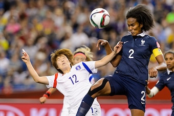 MONTREAL, QC - JUNE 21:  Yoo Younga #12 of Korea Republic and Wendie Renard #2 of France jump for the ball during the 2015 FIFA Women's World Cup Round of 16 match at Olympic Stadium on June 21, 2015 in Montreal, Quebec, Canada.  (Photo by Minas Panagiota