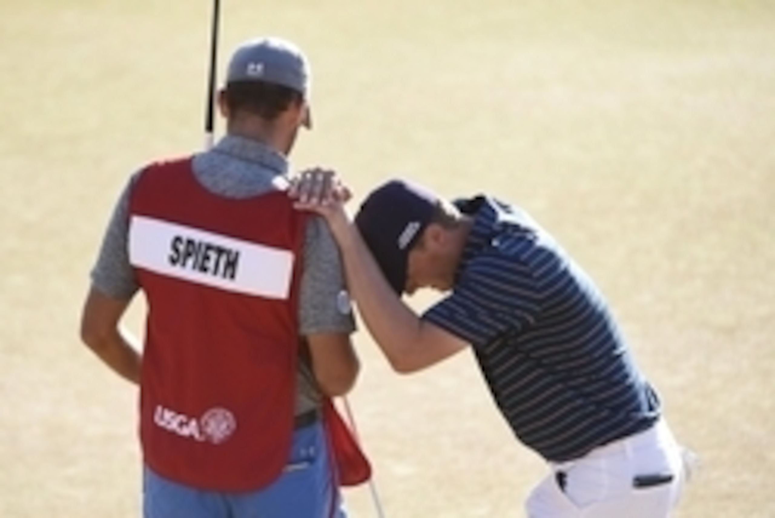 Jun 21, 2015; University Place, WA, USA; Jordan Spieth (right) leans on caddie Michael Greller on the 18th green in the final round of the 2015 U.S. Open golf tournament at Chambers Bay. Mandatory Credit: Kyle Terada-USA TODAY Sports