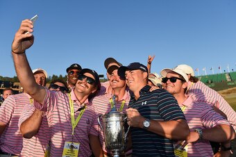 UNIVERSITY PLACE, WA - JUNE 21:  Jordan Spieth of the United States poses with the trophy amid a group of workers after winning the 115th U.S. Open Championship at Chambers Bay on June 21, 2015 in University Place, Washington.  (Photo by Ross Kinnaird/Get