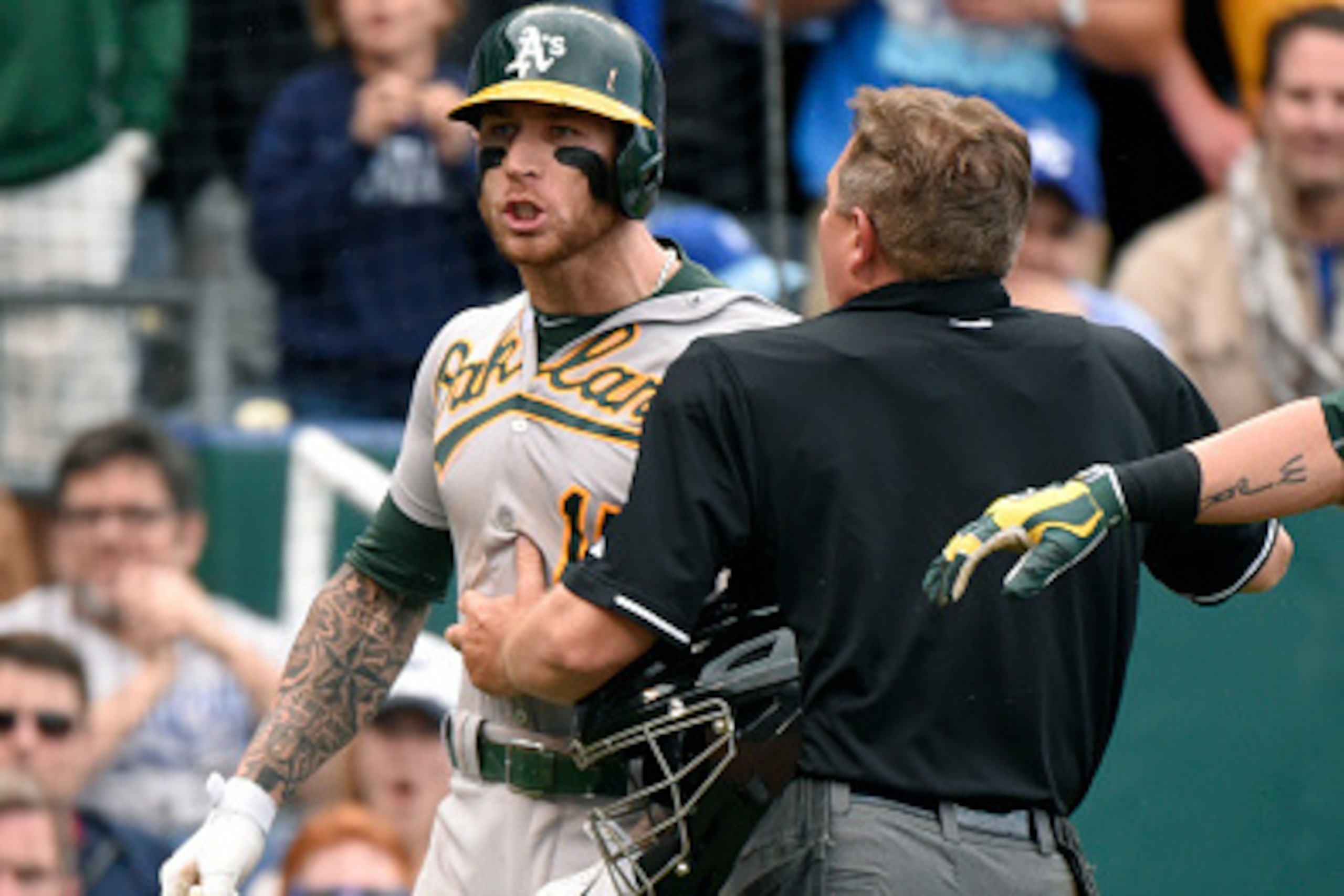 KANSAS CITY, MO - APRIL 19: Brett Lawrie #15 of the Oakland Athletics is held back by plate umpire Greg Gibson after be was almost hit by a pitch thrown by Kelvin Herrera of the Kansas City Royals in the eighth inning April 19, 2015 at Kauffman Stadium i KANSAS CITY, MO - APRIL 19: Brett Lawrie #15 of the Oakland Athletics is held back by plate umpire Greg Gibson after be was almost hit by a pitch thrown by Kelvin Herrera of the Kansas City Royals in the eighth inning April 19, 2015 at Kauffman Stadium i