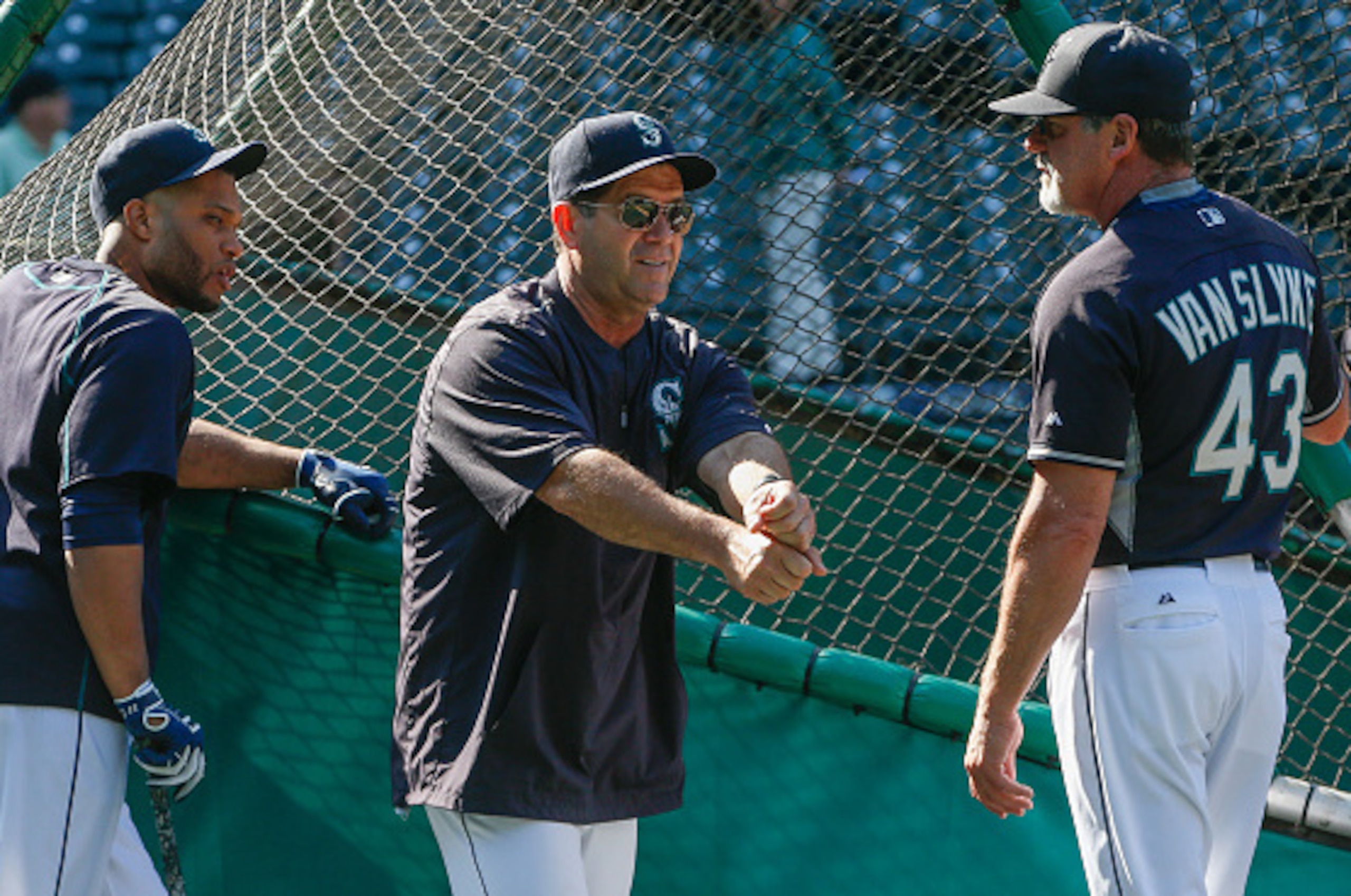 SEATTLE, WA - JUNE 20: Newly hired hitting coach Edgar Martinez #11 (center) of the Seattle Mariners talks with outfield coach Andy Van Slyke #43 as Robinson Cano #22 listens in prior to the game against the Houston Astros at Safeco Field on June 20, 2015
